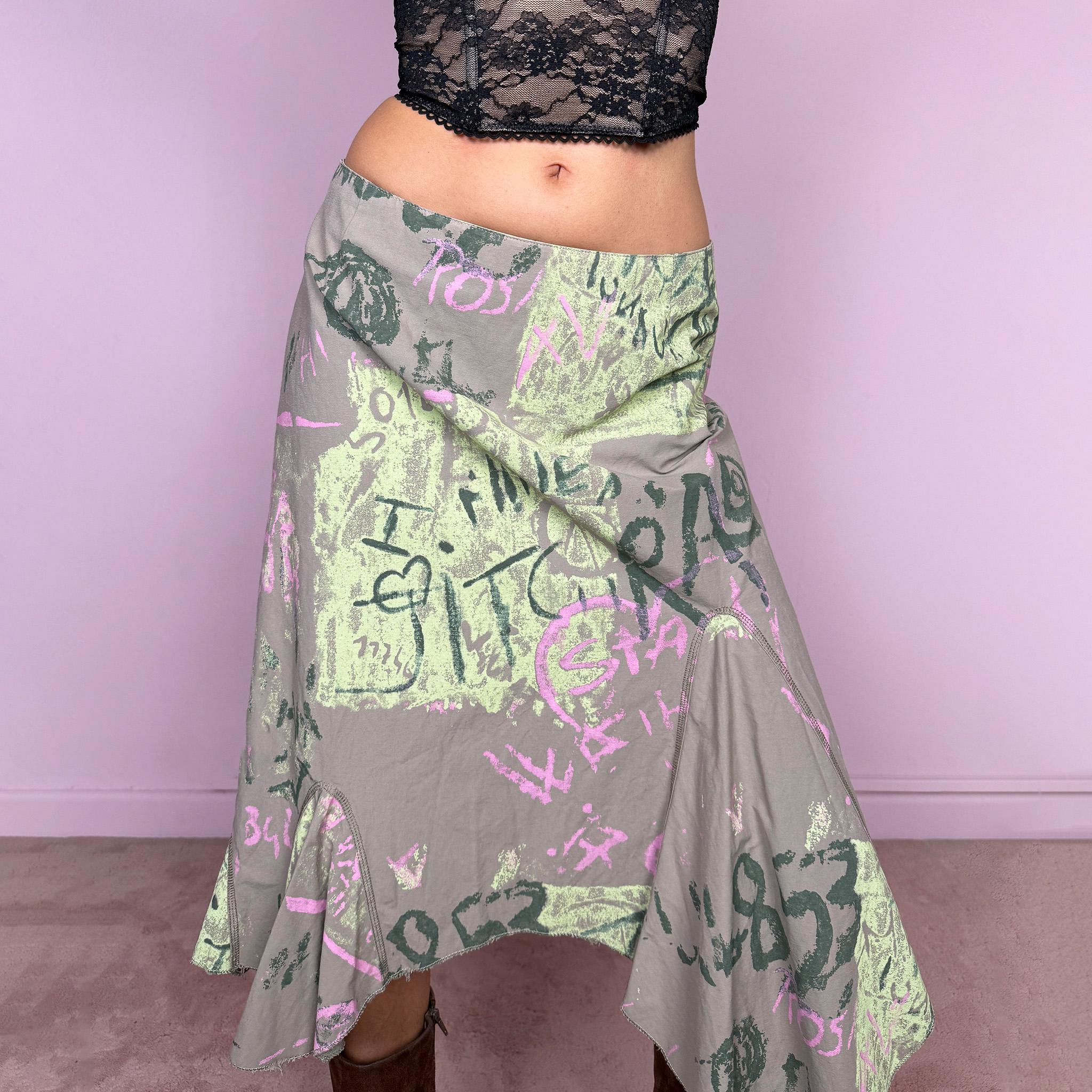 Vintage 2000s deconstructed avant garde midi skirt in green with an abstract graphic print and asymmetric hem. Features a layered draped panel design and back zip closure, no stretch. Can be worn high waisted for size M or mid to low rise for XS/S. Made in France from a 55% polyamide and 45% cotton blend. Great vintage condition.