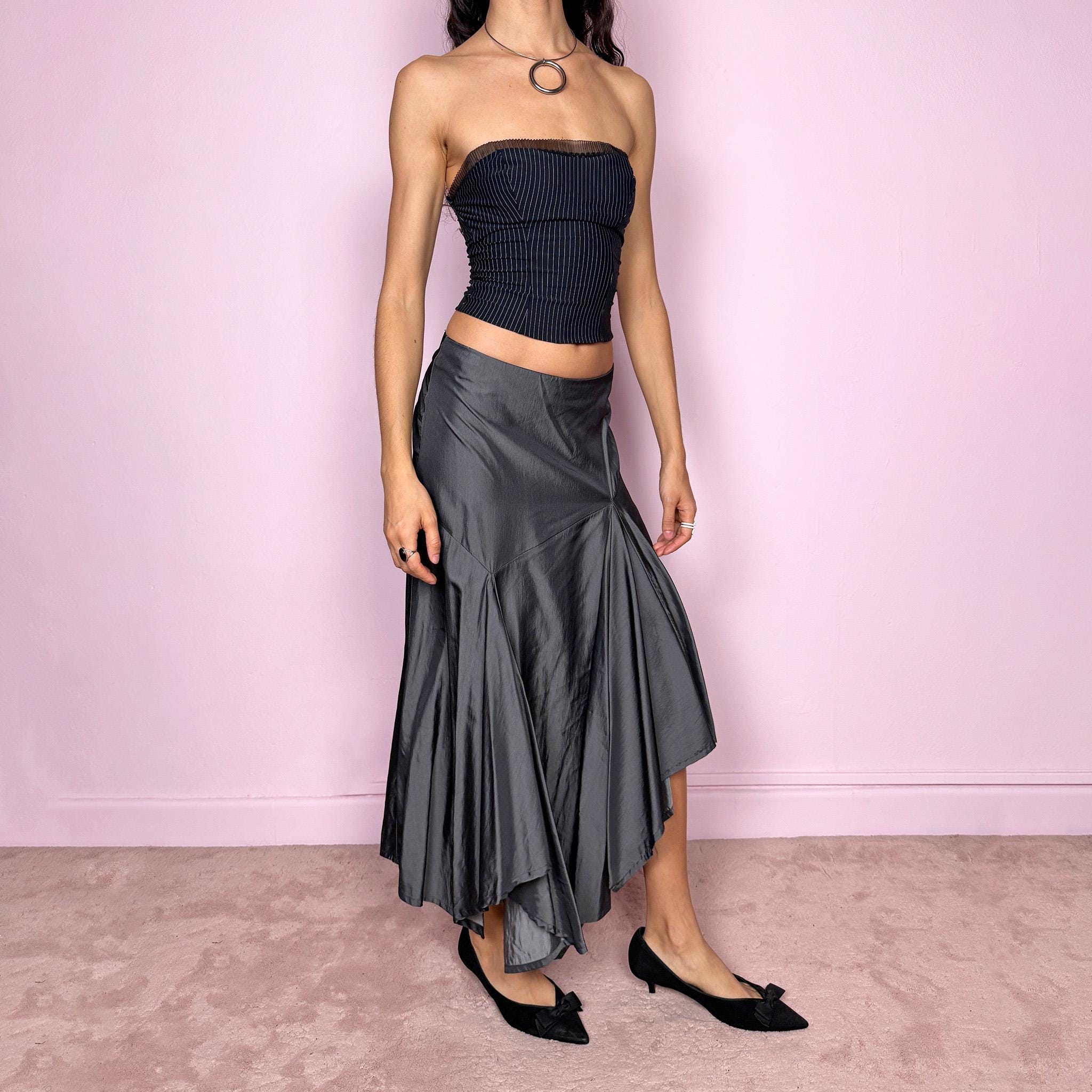 Vintage 2000s silver gray midi skirt with an avant garde asymmetric deconstructed design and fluid godet panel details. Features a glossy satin-like finish, no stretch structure, and back zip closure. Can be worn low rise for size S or mid rise for size M. Perfect for formal, statement, or evening wear. Made from a polyester viscose blend. Excellent vintage condition.