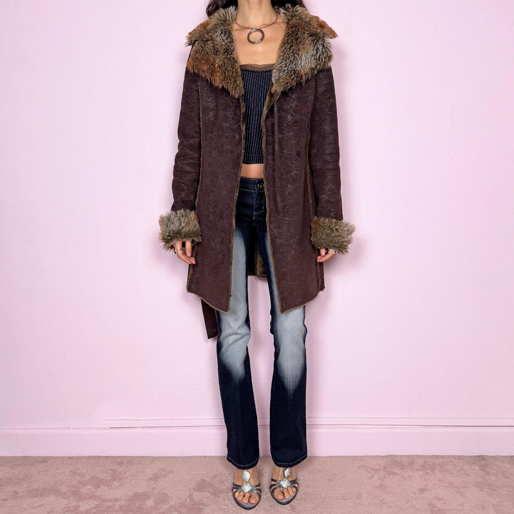 Vintage 2000s brown long coat in a statement penny lane style with a fitted silhouette. Features snap button closure, matching fabric belt, and plush brown and beige faux fur lining at the collar and cuffs. Perfect for city girl winter and Y2K styling. Made from a polyester acrylic blend. Excellent vintage condition.