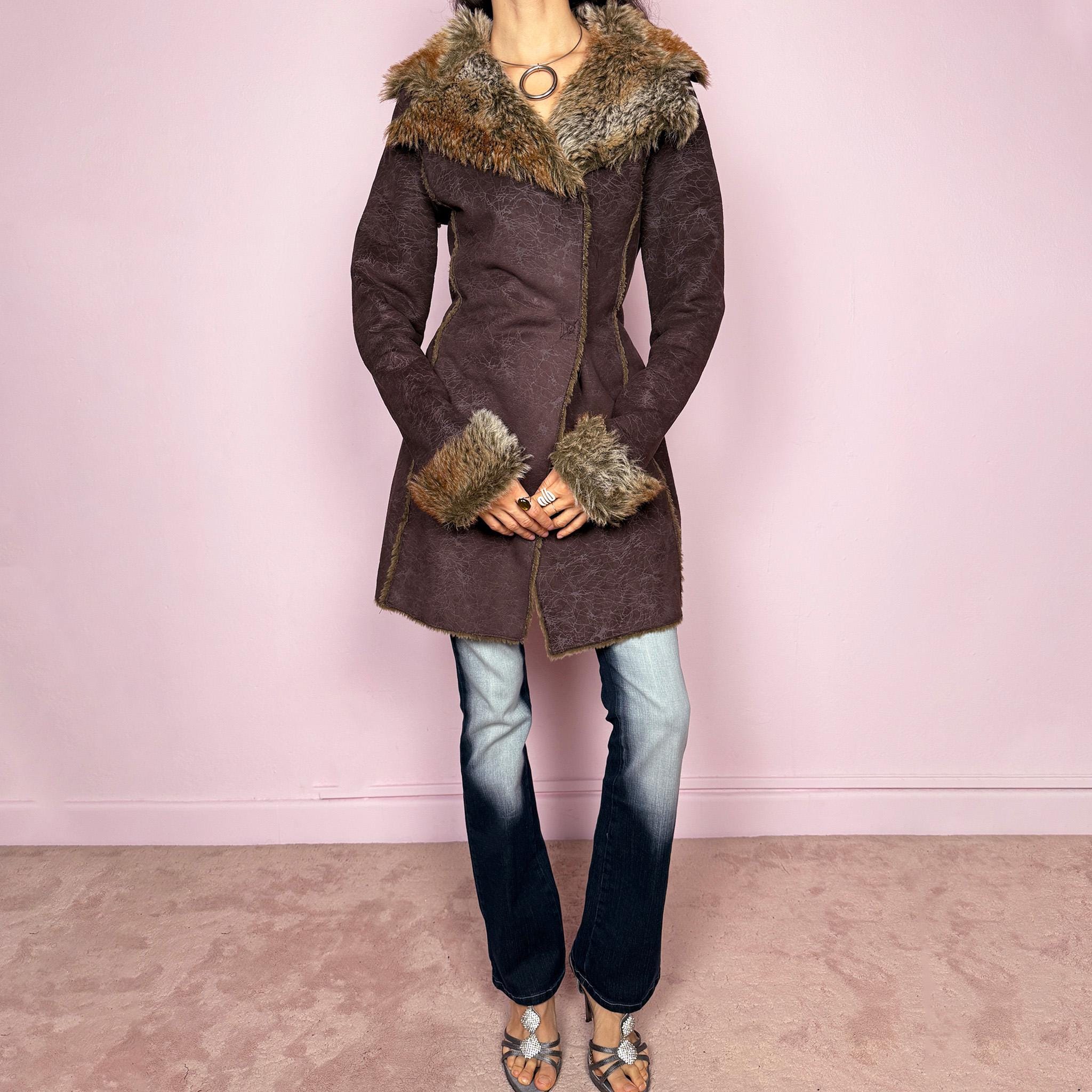 Vintage 2000s brown long coat in a statement penny lane style with a fitted silhouette. Features snap button closure, matching fabric belt, and plush brown and beige faux fur lining at the collar and cuffs. Perfect for city girl winter and Y2K styling. Made from a polyester acrylic blend. Excellent vintage condition.