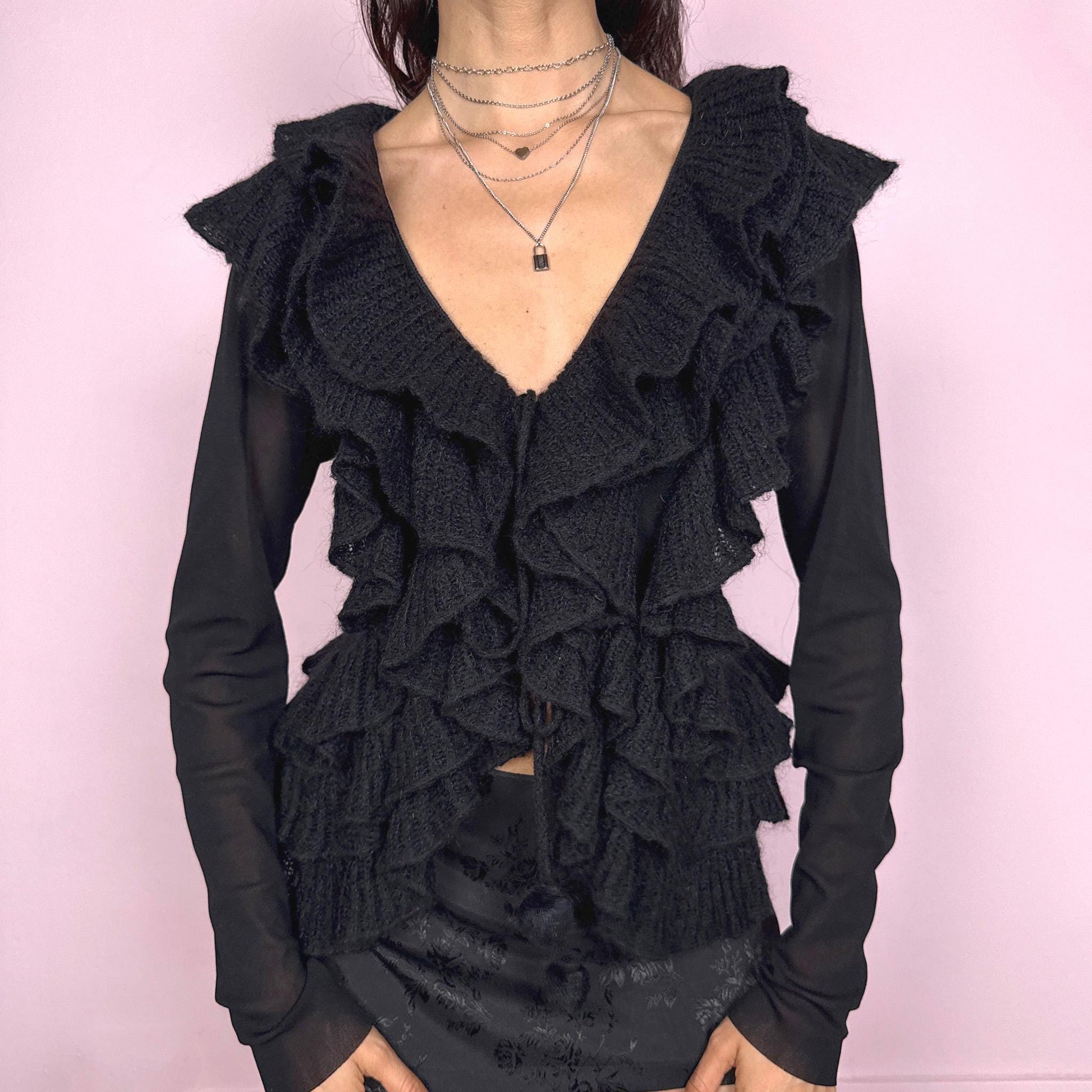 Vintage 2000s avant garde black mesh long sleeve tie front top featuring cascading knit ruffles over a sheer polyamide base, creating a dark romantic silhouette with soft texture and fluid movement. Ruffles are crafted from 30% kid mohair with a polyamide acrylic blend. Ideal for evening, night, party, or statement layering. Made in Italy by a French brand. Excellent vintage condition.