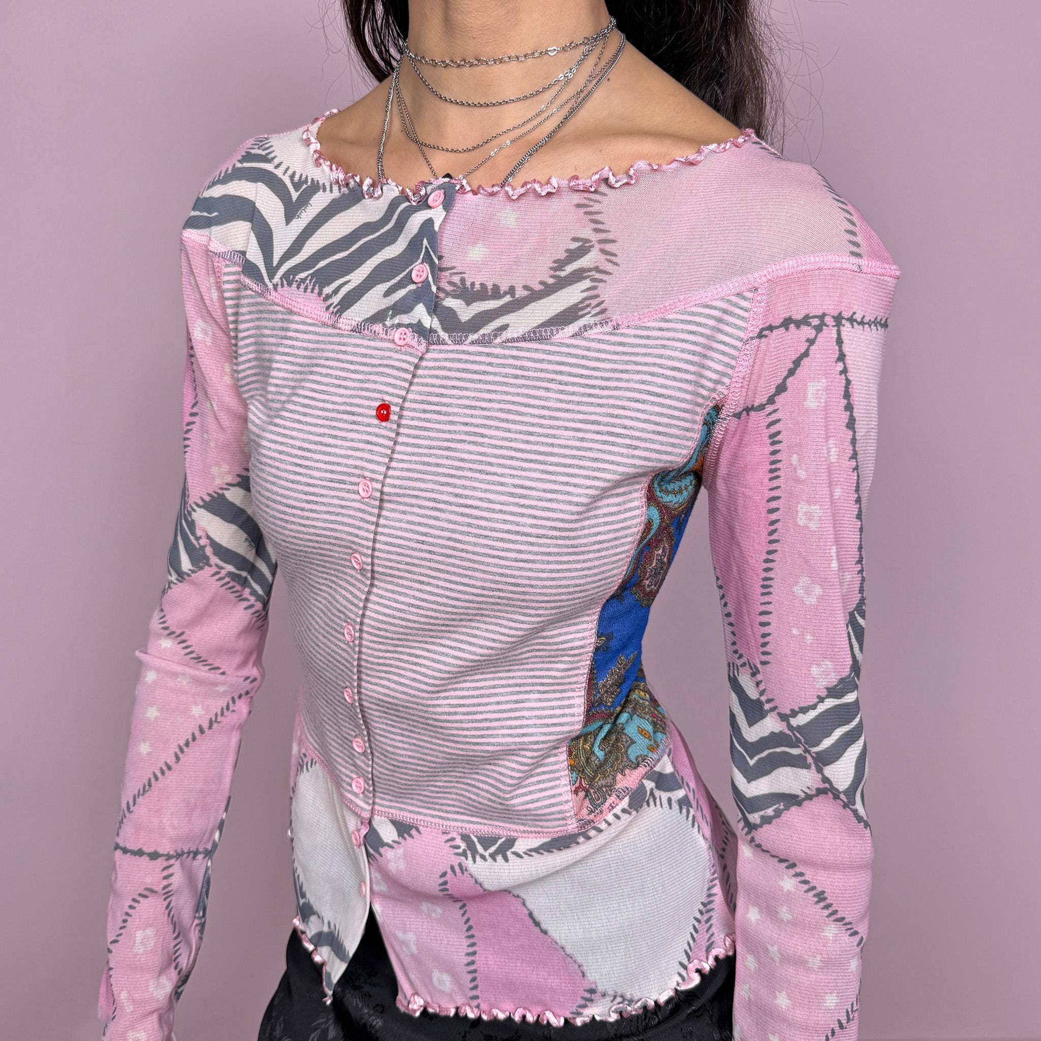 Vintage 2000s pink coquette style long sleeve stretchy fitted top with mesh panels and sleeves featuring an abstract print, and a striped front with button closure. Finished with a lettuce hem for a soft feminine look. Perfect for spring or summer layering. Made by a French brand. Excellent vintage condition.