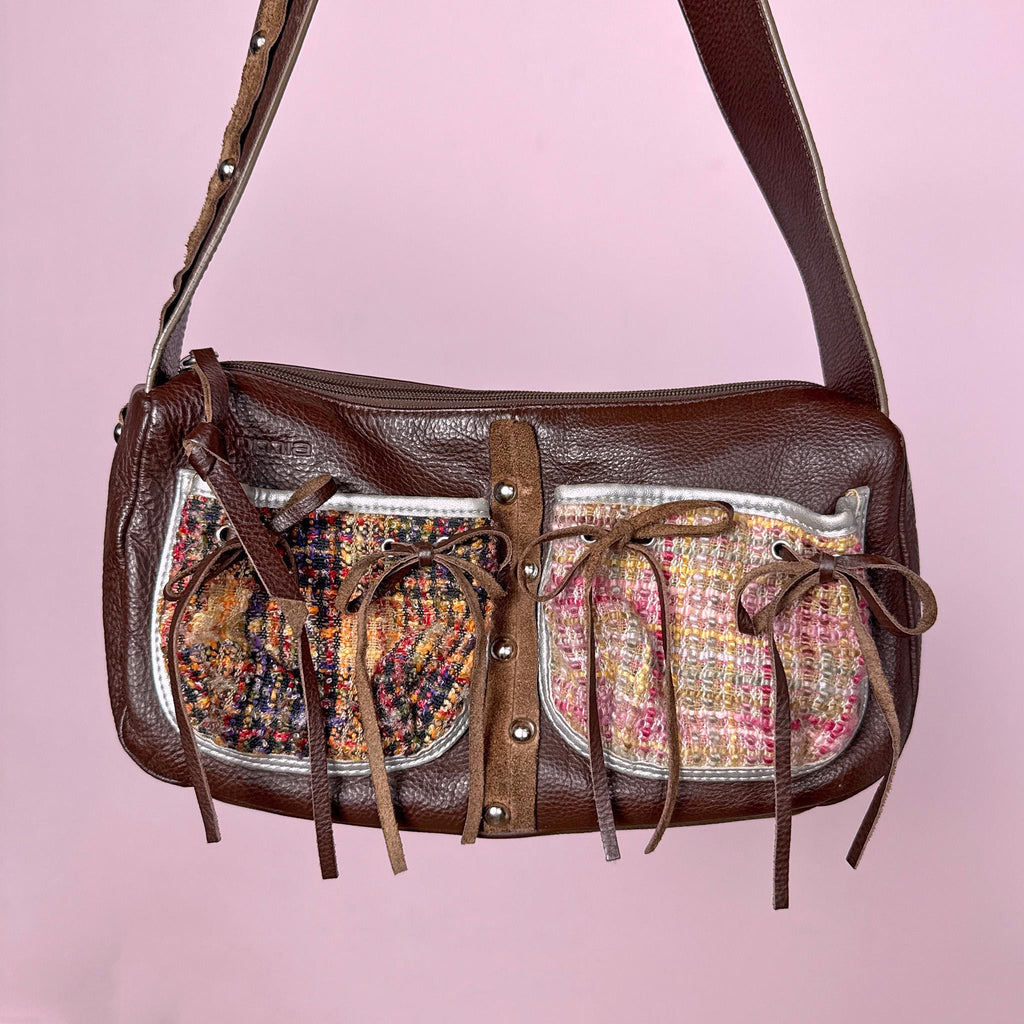 Vintage 2000s genuine leather shoulder bag made in Italy by Cromia, crafted in rich brown leather with textured woven panel details, delicate tie ribbon accents, and studded details. Features a structured baguette silhouette with zip closure and artisanal finishes, blending boho romantic and fairycore aesthetics. Great vintage condition.