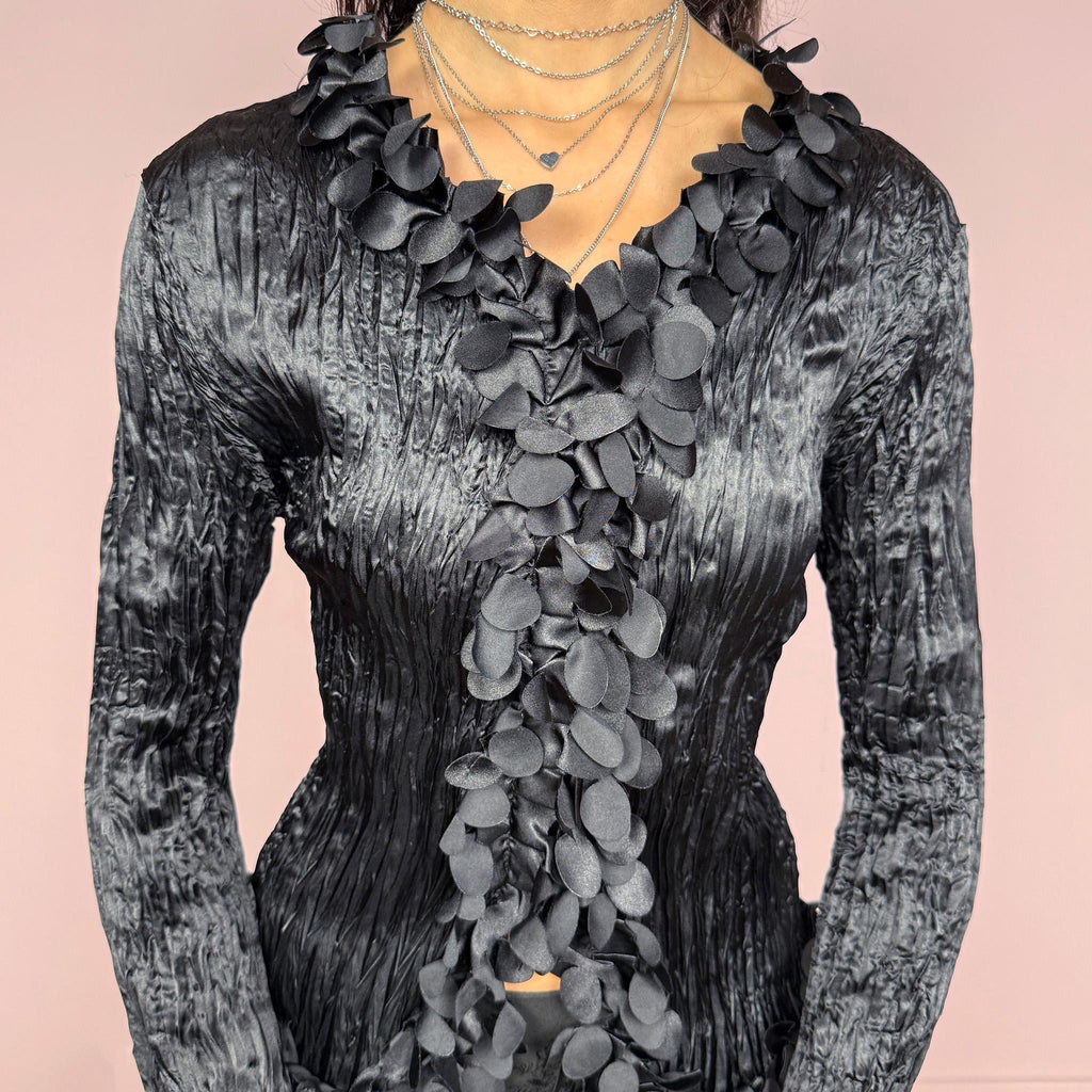 Vintage 2000s black crinkle pleated top with long flared sleeves. Features a button front and dramatic 3D floral appliqué cascading along the neckline and opening for an avant garde look. Perfect for formal, party, night, or evening wear. Made by a French brand. Excellent vintage condition.