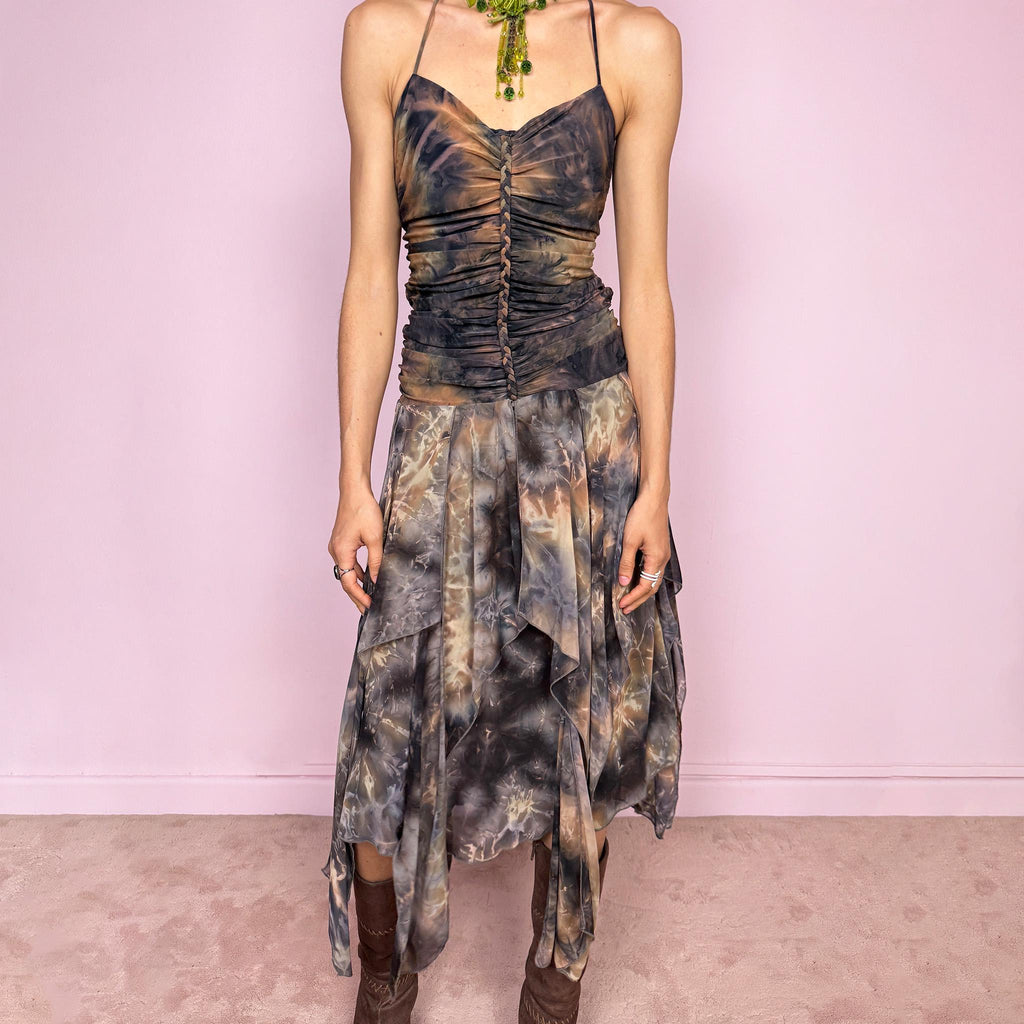 Vintage 2000s multicolored halter midi dress with a tie-neck design and ruched stretchy bodice for a flattering fitted silhouette. Features a dramatic asymmetric handkerchief hem and bold psychedelic tie-dye print in earthy tones. Stunning statement piece perfect for festivals, boho fairy styling, or summer events. Made in USA from polyester. Excellent vintage condition.