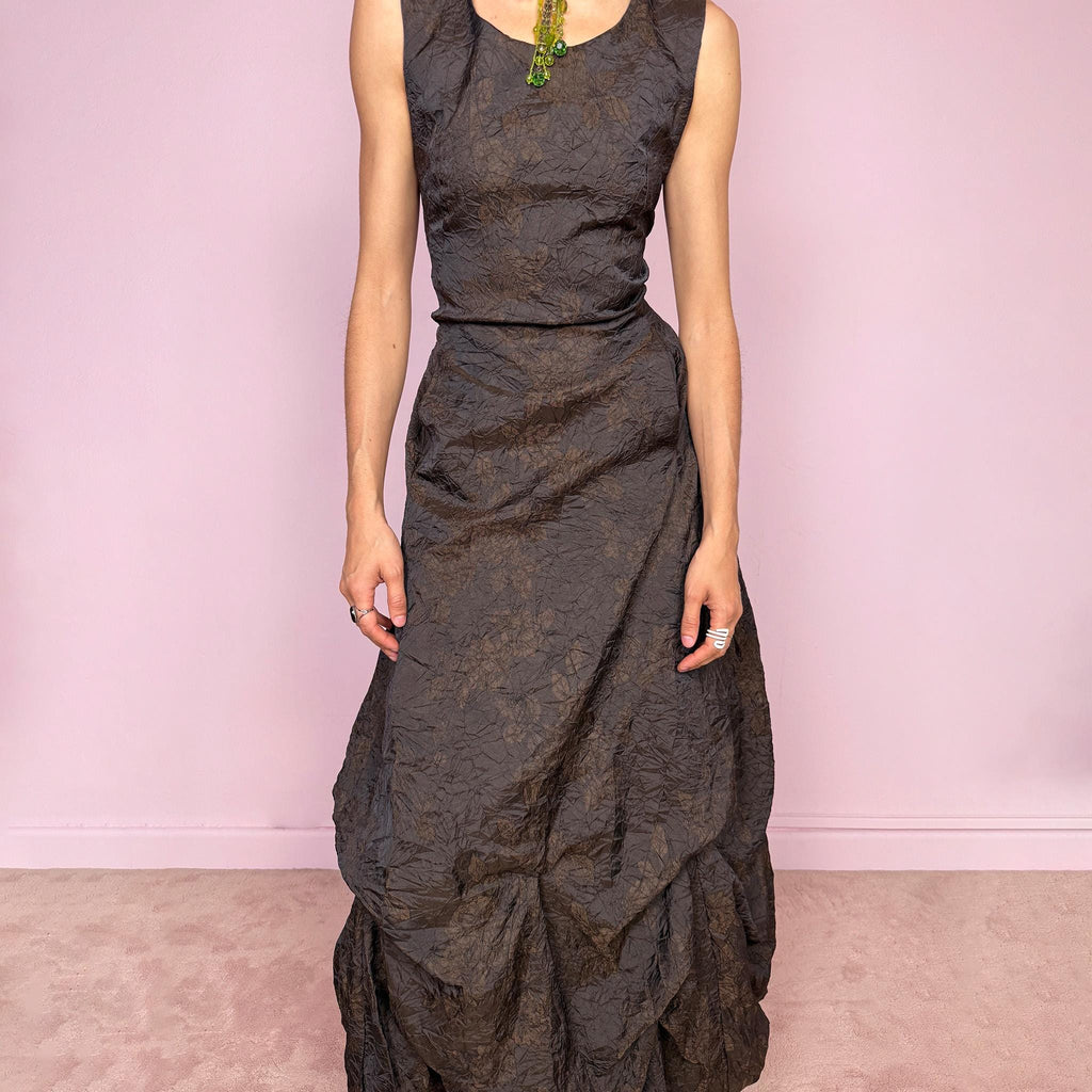 Vintage 90s dark brown sleeveless midi dress with a crinkle texture and subtle floral pattern. Features a voluminous draped balloon bubble hem and lace-up back for a fitted silhouette. Non-stretch design with avant-garde formal elegance, perfect for night events or statement evenings. Made in France from 50% acetate and 50% polyester. Excellent vintage condition.