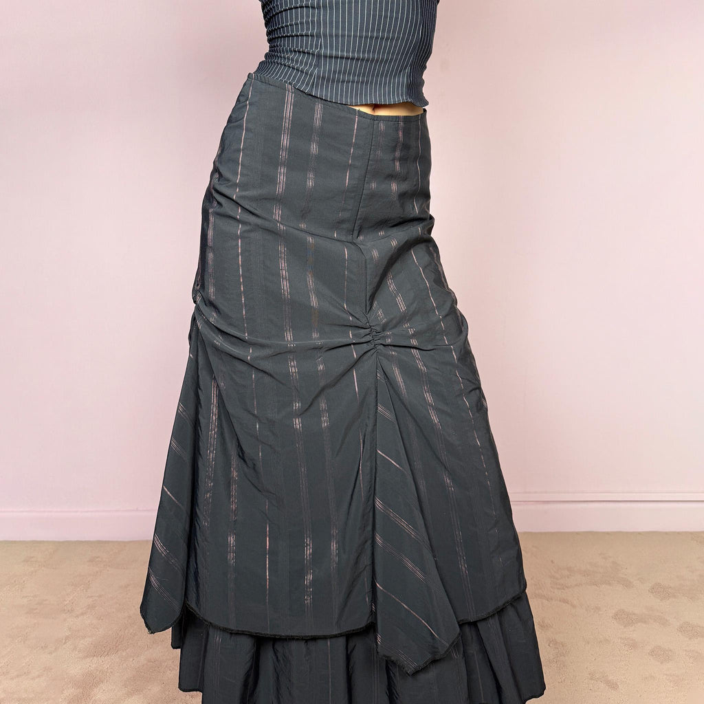 Vintage 2000s black midi skirt with pink pinstripes, a layered deconstructed silhouette, ruched details, and ruffled hem. This dark avant-garde piece has a structured no-stretch fit with back zip closure. Can be worn high waisted for size S or lower rise for XXS and XS. Made in France from a cotton, polyamide, and polyester blend. Great vintage condition.