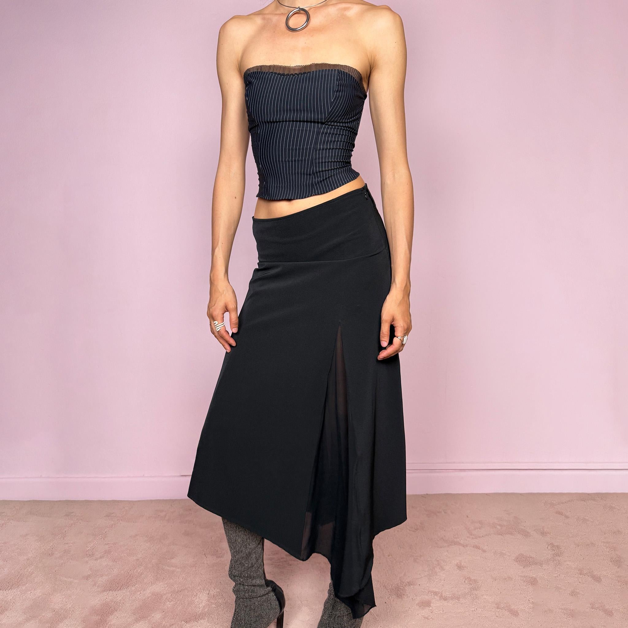 Vintage 2000s black midi skirt with an avant-garde deconstructed look. Features a pointed asymmetric hem, semi-sheer mesh panel detail, side zip closure, and a smooth no-stretch fit with a fluid draped silhouette. Perfect for dark styling and evening events. Can be worn high waisted for S or lower rise for XS/XXS. Made from a polyester elastane blend. Excellent vintage condition.