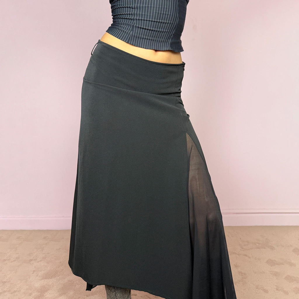 Vintage 2000s black midi skirt with an avant-garde deconstructed look. Features a pointed asymmetric hem, semi-sheer mesh panel detail, side zip closure, and a smooth no-stretch fit with a fluid draped silhouette. Perfect for dark styling and evening events. Can be worn high waisted for S or lower rise for XS/XXS. Made from a polyester elastane blend. Excellent vintage condition.