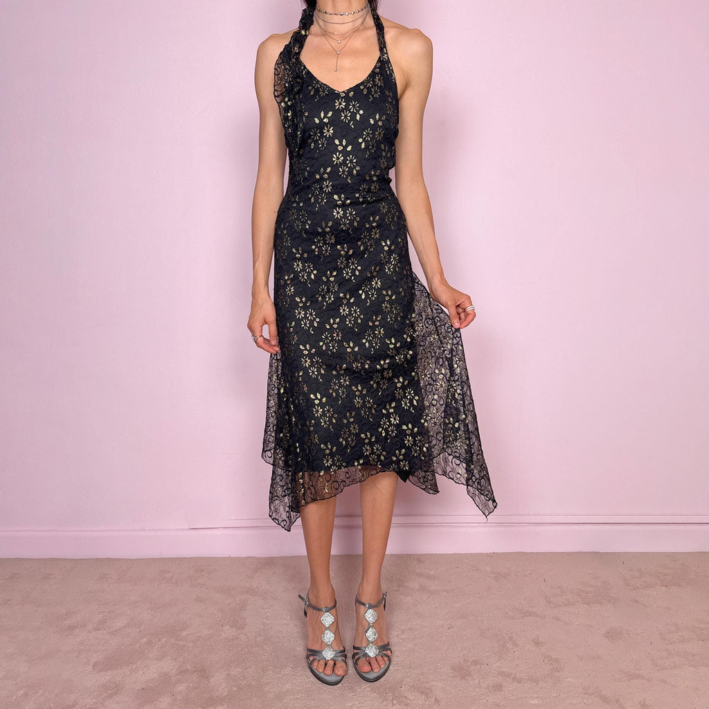 Vintage 2000s black backless halter midi dress with a V neckline, stretchy fit, asymmetric handkerchief hem, and lace mesh overlay with a gold floral pattern. Dark romantic statement piece for parties, nights out, or elegant evening events. Made by a Spanish designer. Excellent vintage condition.