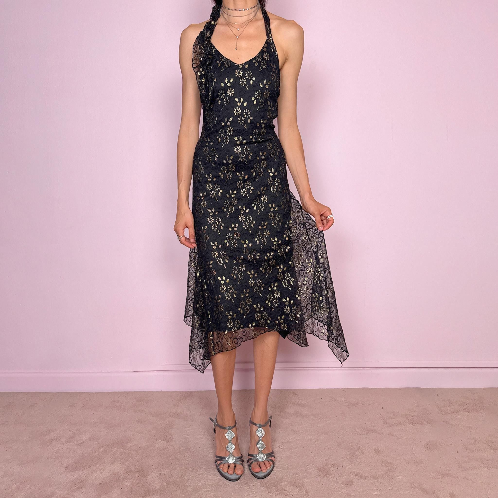 Vintage 2000s black backless halter midi dress with a V neckline, stretchy fit, asymmetric handkerchief hem, and lace mesh overlay with a gold floral pattern. Dark romantic statement piece for parties, nights out, or elegant evening events. Made by a Spanish designer. Excellent vintage condition.