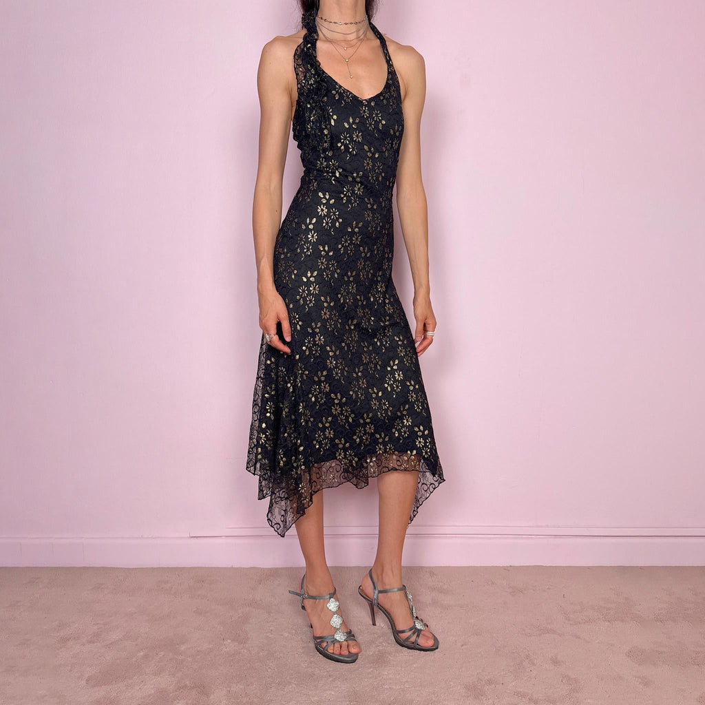 Vintage 2000s black backless halter midi dress with a V neckline, stretchy fit, asymmetric handkerchief hem, and lace mesh overlay with a gold floral pattern. Dark romantic statement piece for parties, nights out, or elegant evening events. Made by a Spanish designer. Excellent vintage condition.
