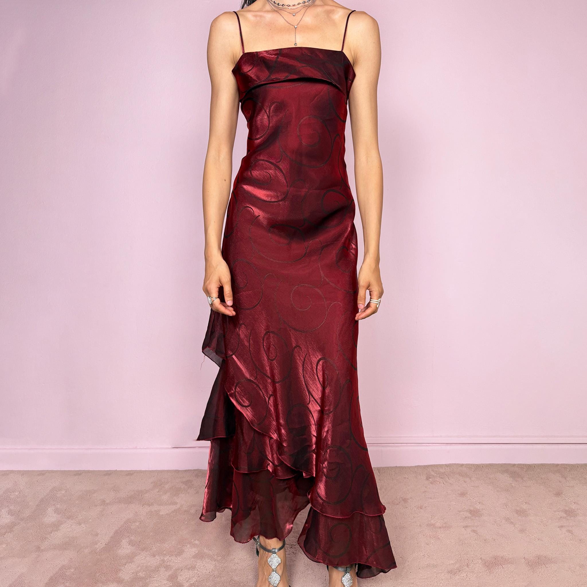 Vintage 2000s statement burgundy midi dress with iridescent shimmer and elegant layered construction. Features spaghetti straps, asymmetrical tiered hem and sheer overlay with swirl pattern. Fluid body-skimming fit with romantic movement, perfect for evening events or occasionwear. Made in France from a polyester elastane blend. Excellent vintage condition.
