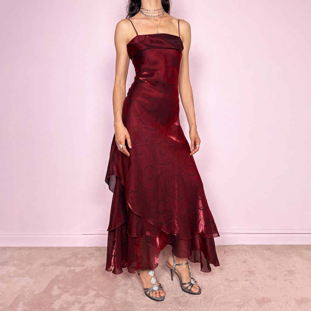 Vintage 2000s statement burgundy midi dress with iridescent shimmer and elegant layered construction. Features spaghetti straps, asymmetrical tiered hem and sheer overlay with swirl pattern. Fluid body-skimming fit with romantic movement, perfect for evening events or occasionwear. Made in France from a polyester elastane blend. Excellent vintage condition.