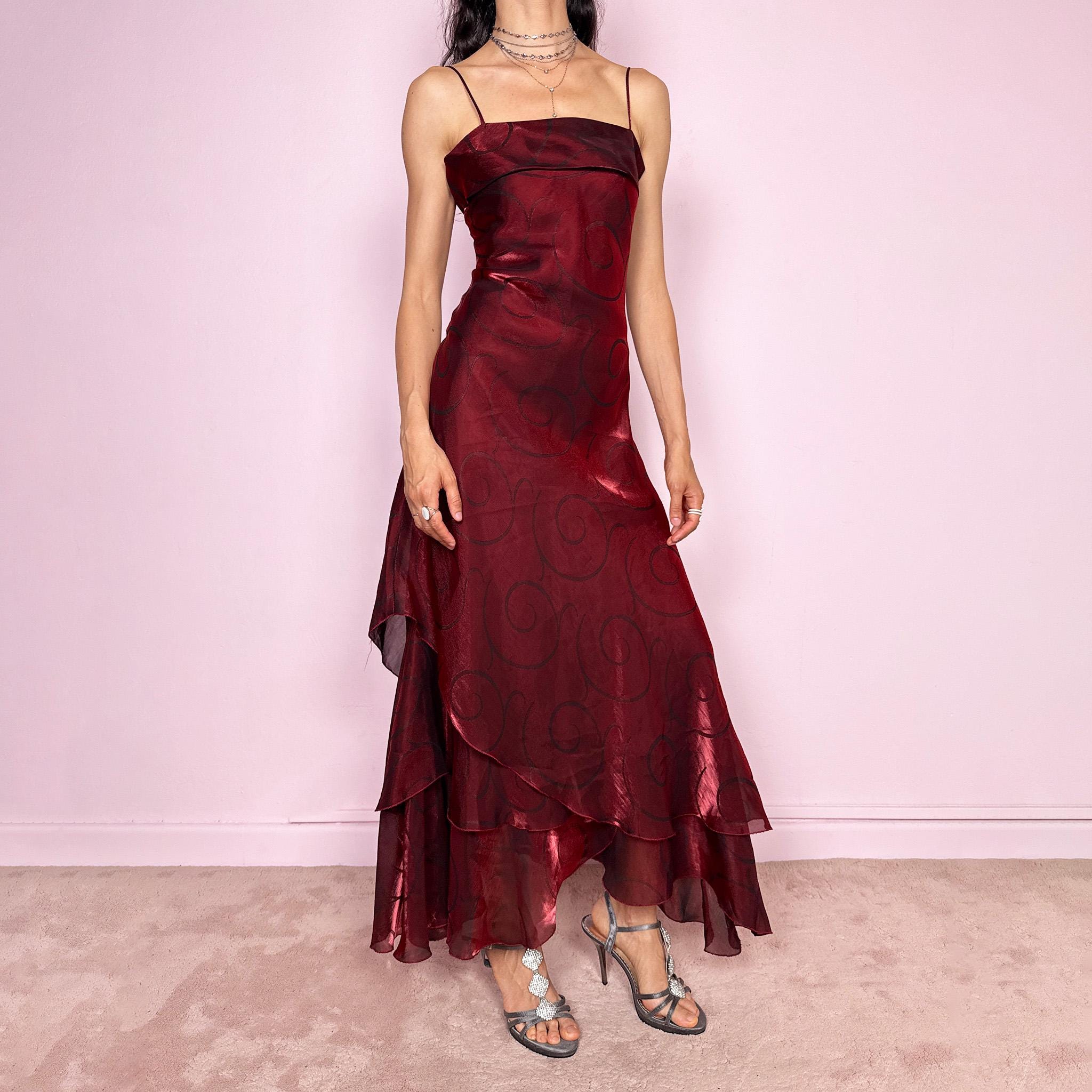 Vintage 2000s statement burgundy midi dress with iridescent shimmer and elegant layered construction. Features spaghetti straps, asymmetrical tiered hem and sheer overlay with swirl pattern. Fluid body-skimming fit with romantic movement, perfect for evening events or occasionwear. Made in France from a polyester elastane blend. Excellent vintage condition.