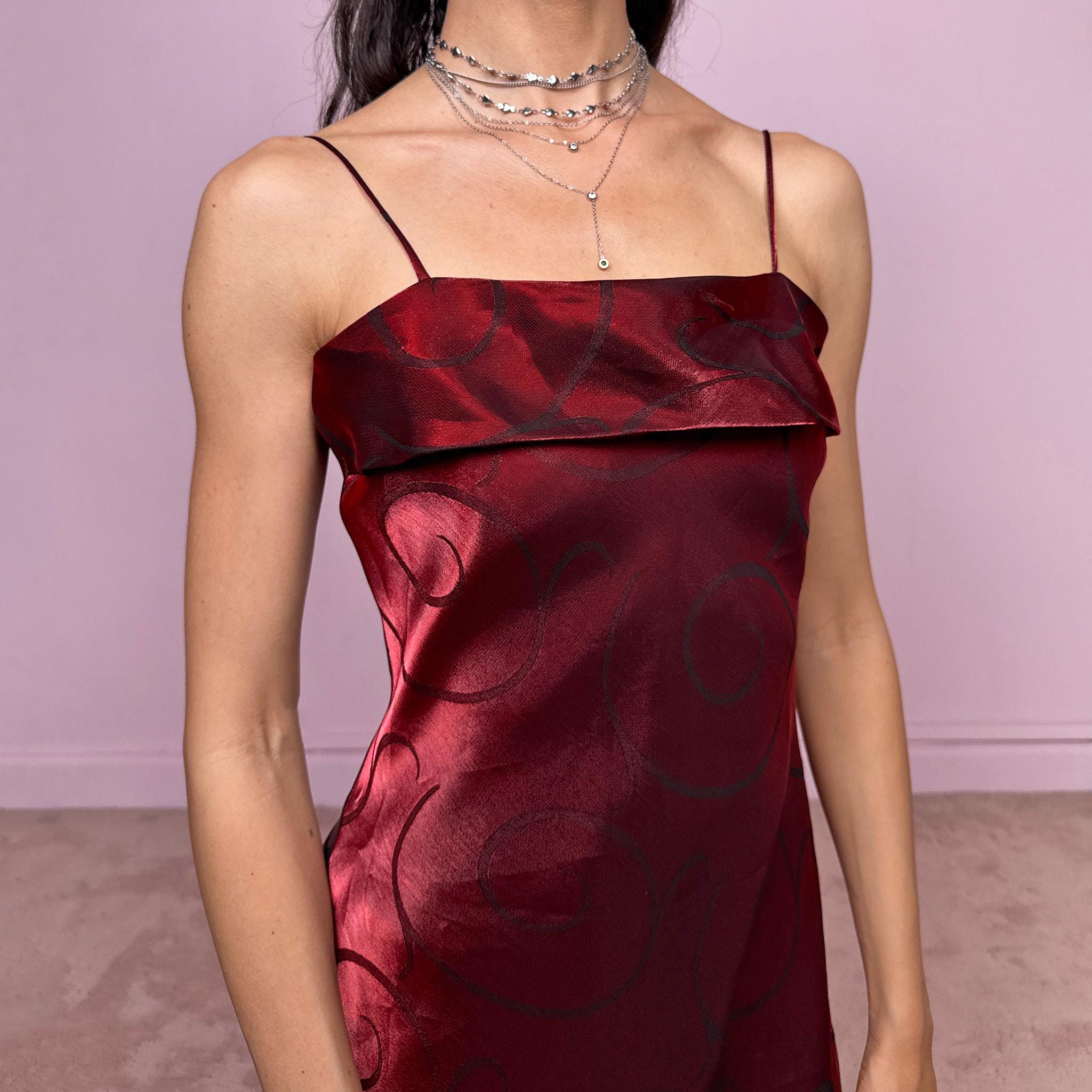 Vintage 2000s statement burgundy midi dress with iridescent shimmer and elegant layered construction. Features spaghetti straps, asymmetrical tiered hem and sheer overlay with swirl pattern. Fluid body-skimming fit with romantic movement, perfect for evening events or occasionwear. Made in France from a polyester elastane blend. Excellent vintage condition.