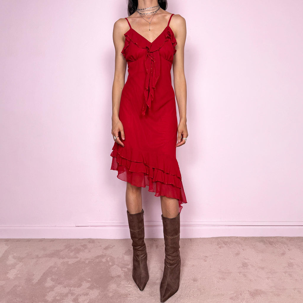 Vintage 2000s romantic red midi dress with a flattering V neckline and adjustable straps. Features delicate ruffle detailing at the bust, subtle beaded accents and an asymmetrical layered ruffle hem for fluid movement. Body-skimming fit with a dreamy coquette feel, perfect for summer parties or date nights. Great vintage condition.