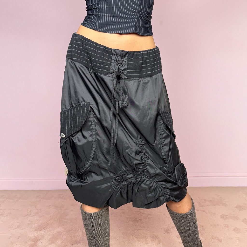 Vintage 2000s black midi skirt with a dark avant-garde parachute-style silhouette, mixed pinstripe panels, ruched construction, oversized utility pockets, tie-front details, elastic waist, and bubble hem. Rare experimental archive piece with dystopian techwear aesthetic by Elisa Cavaletti by Daniela Dallavalle. Can be worn high waisted for L or lower rise for M. Made in Italy from a polyamide polyurethane blend. Great vintage condition.