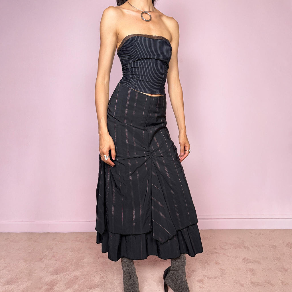 Vintage 2000s black midi skirt with pink pinstripes, a layered deconstructed silhouette, ruched details, and ruffled hem. This dark avant-garde piece has a structured no-stretch fit with back zip closure. Can be worn high waisted for size S or lower rise for XXS and XS. Made in France from a cotton, polyamide, and polyester blend. Great vintage condition.