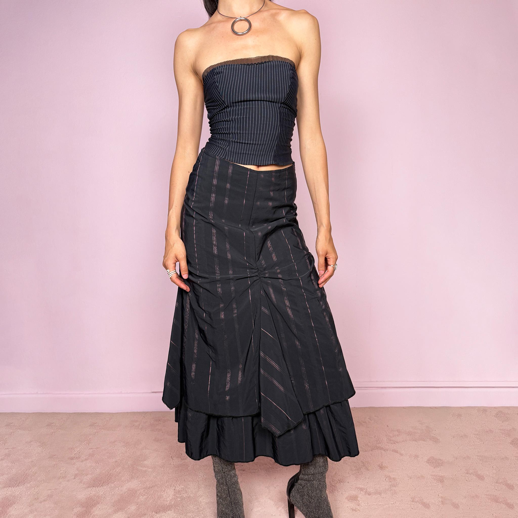 Vintage 2000s black midi skirt with pink pinstripes, a layered deconstructed silhouette, ruched details, and ruffled hem. This dark avant-garde piece has a structured no-stretch fit with back zip closure. Can be worn high waisted for size S or lower rise for XXS and XS. Made in France from a cotton, polyamide, and polyester blend. Great vintage condition.