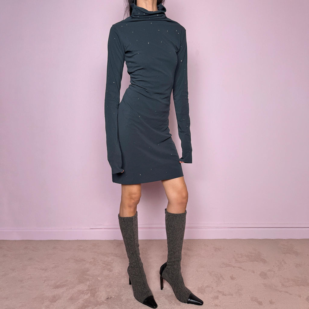 Vintage 2000s gray mini dress made in Italy from a stretchy polyamide-elastane mesh fabric. Features long sleeves, a draped high neckline, a body-skimming silhouette that flares at the hem, and delicate mini studded details throughout. A sleek dark minimal Y2K piece with an avant-garde feel. Excellent vintage condition.