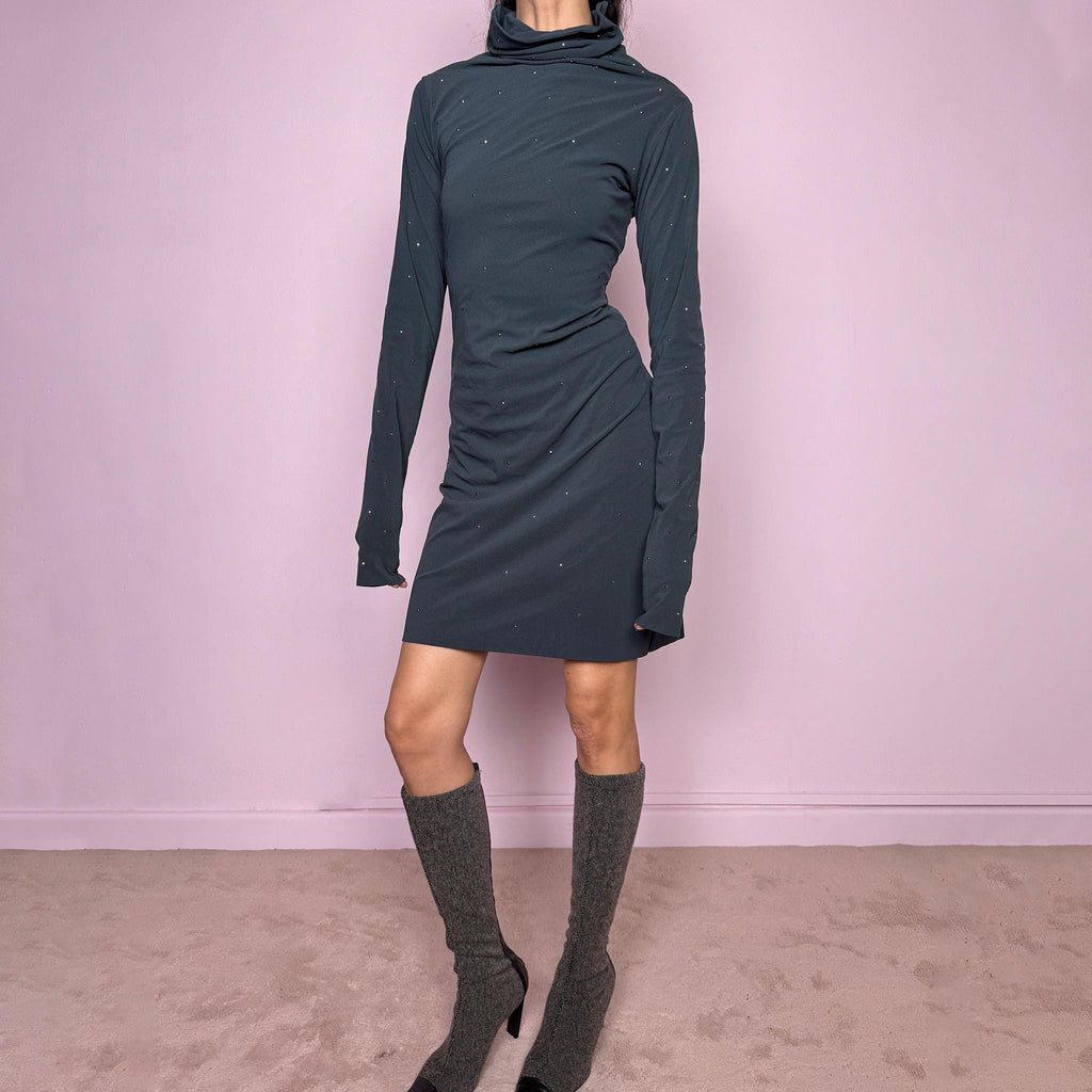 Vintage 2000s gray mini dress made in Italy from a stretchy polyamide-elastane mesh fabric. Features long sleeves, a draped high neckline, a body-skimming silhouette that flares at the hem, and delicate mini studded details throughout. A sleek dark minimal Y2K piece with an avant-garde feel. Excellent vintage condition.