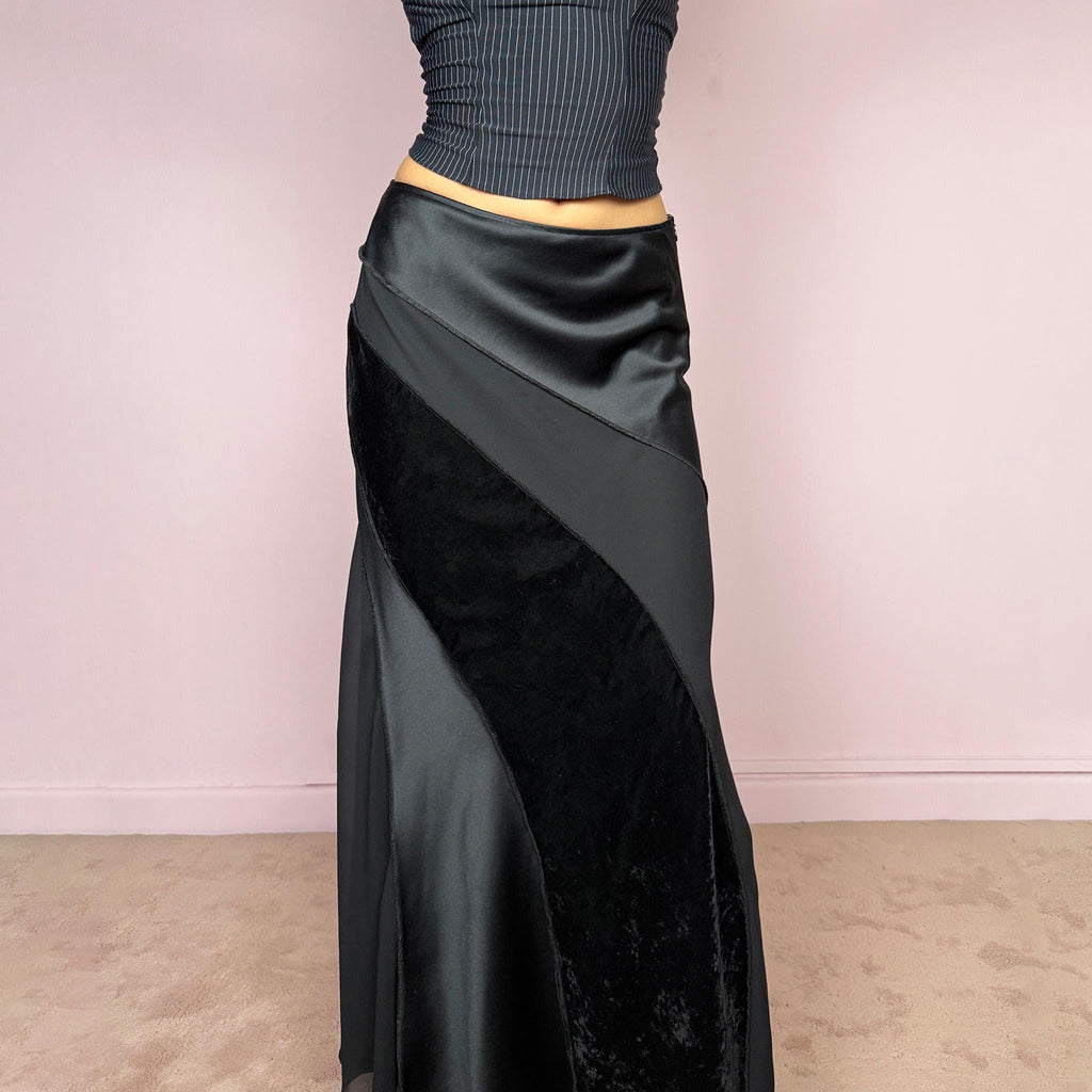Vintage 2000s black midi skirt with a formal avant-garde minimal look, mixed velvet, satin, and sheer flare panels, asymmetric diagonal construction, side zip closure, and structured no-stretch fit. Elegant statement piece for evening, night, or event styling. Can be worn high waisted for S or lower rise for XS/XXS. Made from polyester. Excellent vintage condition.