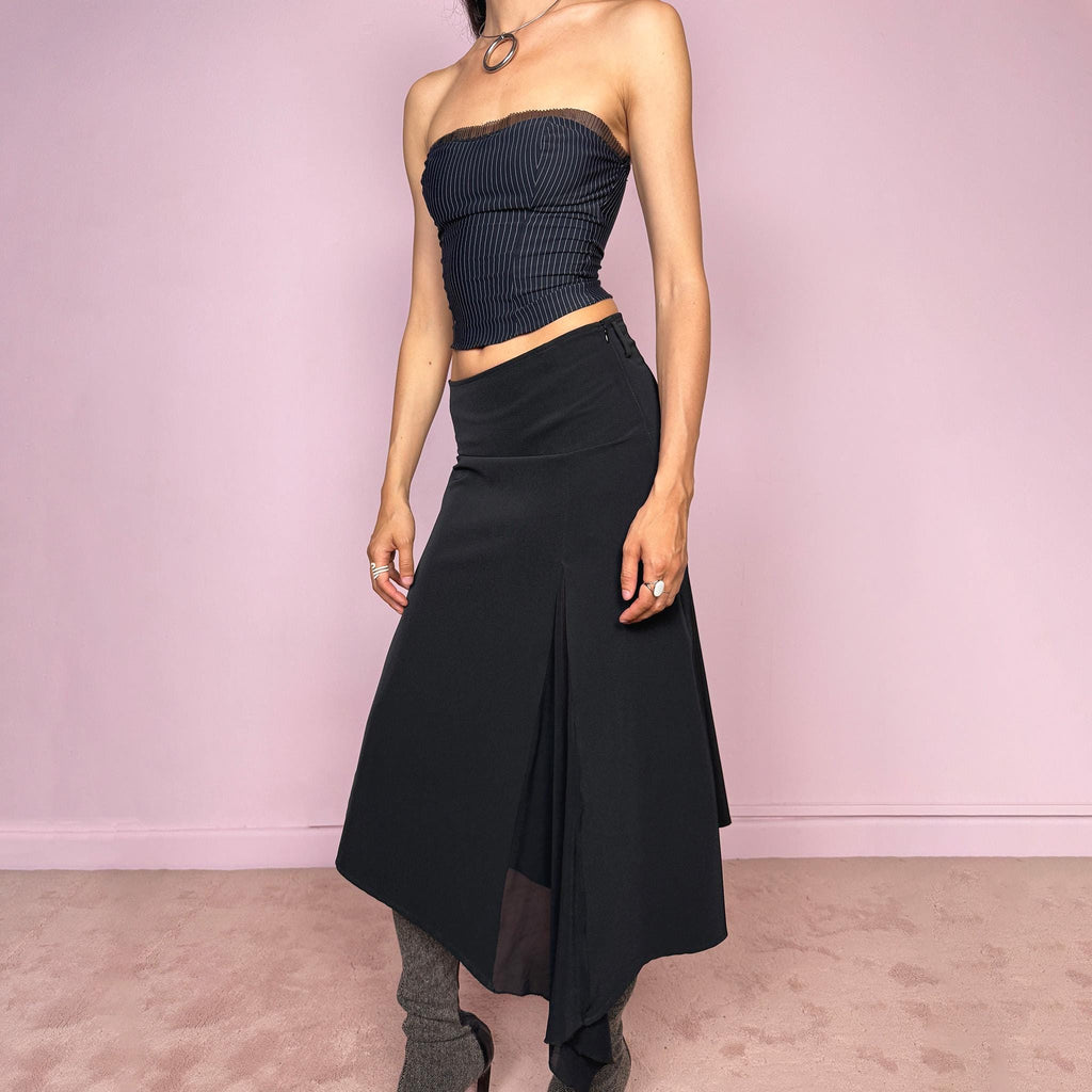 Vintage 2000s black midi skirt with an avant-garde deconstructed look. Features a pointed asymmetric hem, semi-sheer mesh panel detail, side zip closure, and a smooth no-stretch fit with a fluid draped silhouette. Perfect for dark styling and evening events. Can be worn high waisted for S or lower rise for XS/XXS. Made from a polyester elastane blend. Excellent vintage condition.