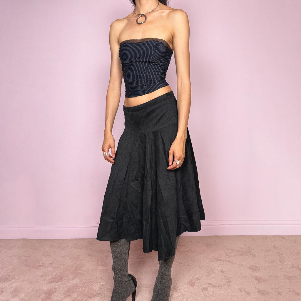 Vintage 2000s black faux suede midi skirt with a dark avant-garde minimal look. Features a softly flared silhouette, asymmetric hem, side zip closure, and structured no-stretch fit. Can be worn mid rise for size S or lower rise for XS. Made from polyester and acetate. Excellent vintage condition.