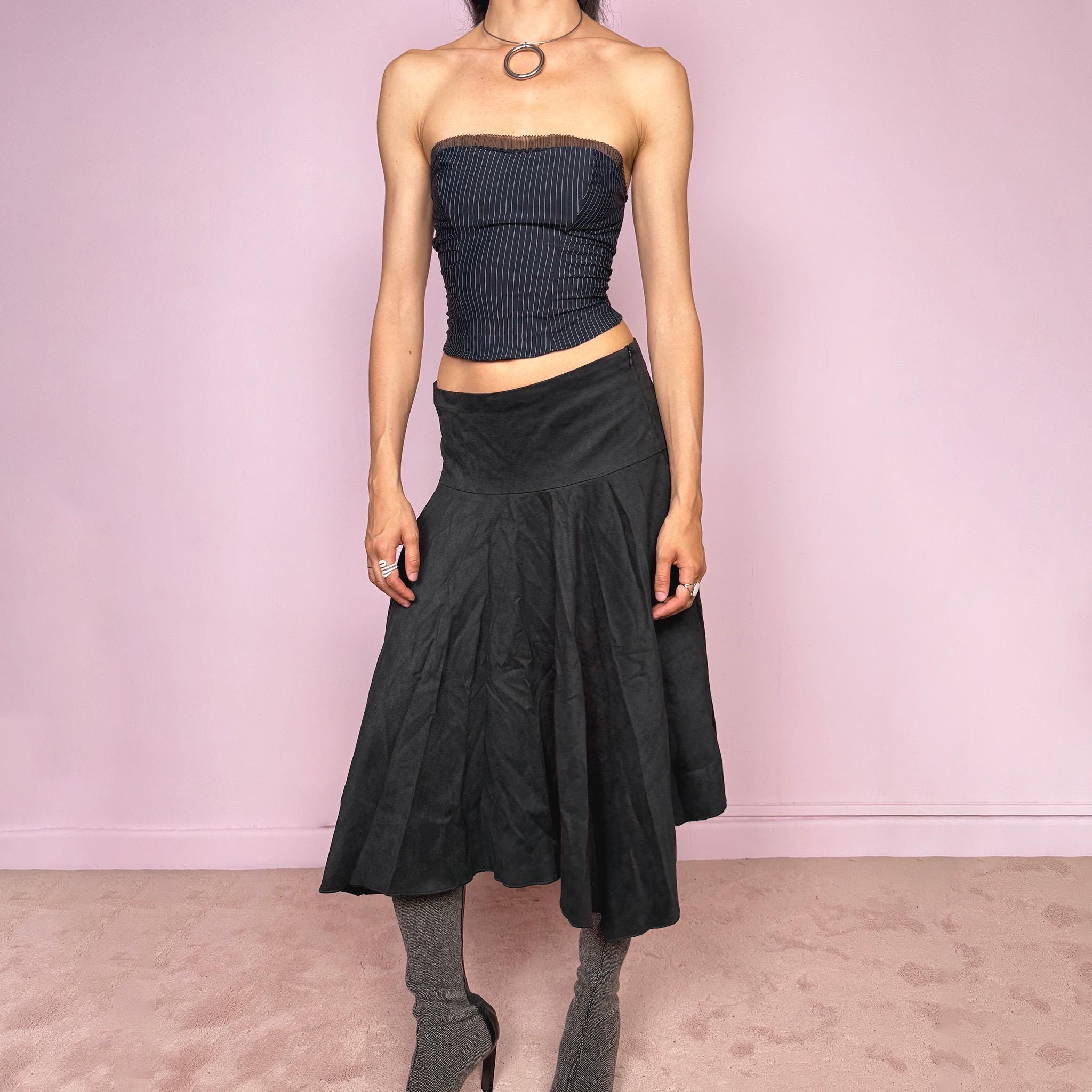 Vintage 2000s black faux suede midi skirt with a dark avant-garde minimal look. Features a softly flared silhouette, asymmetric hem, side zip closure, and structured no-stretch fit. Can be worn mid rise for size S or lower rise for XS. Made from polyester and acetate. Excellent vintage condition.
