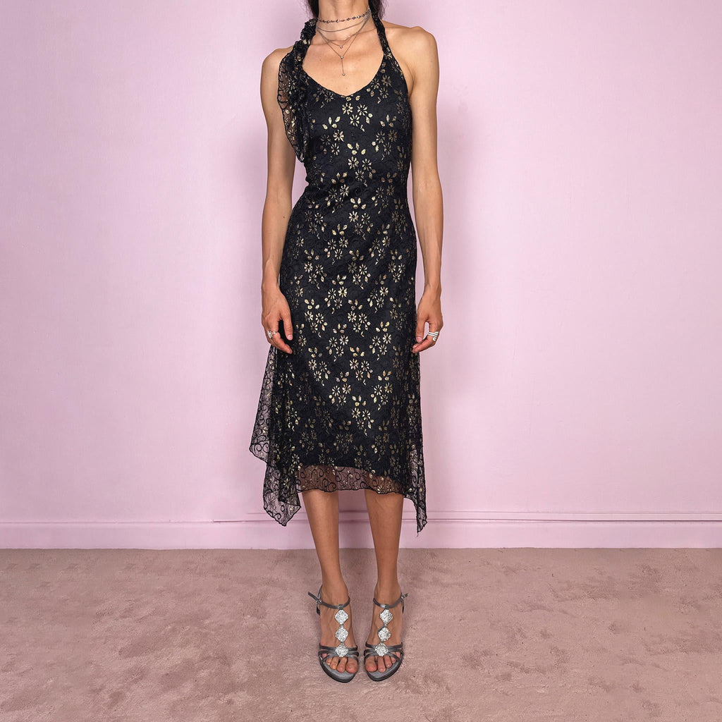 Vintage 2000s black backless halter midi dress with a V neckline, stretchy fit, asymmetric handkerchief hem, and lace mesh overlay with a gold floral pattern. Dark romantic statement piece for parties, nights out, or elegant evening events. Made by a Spanish designer. Excellent vintage condition.