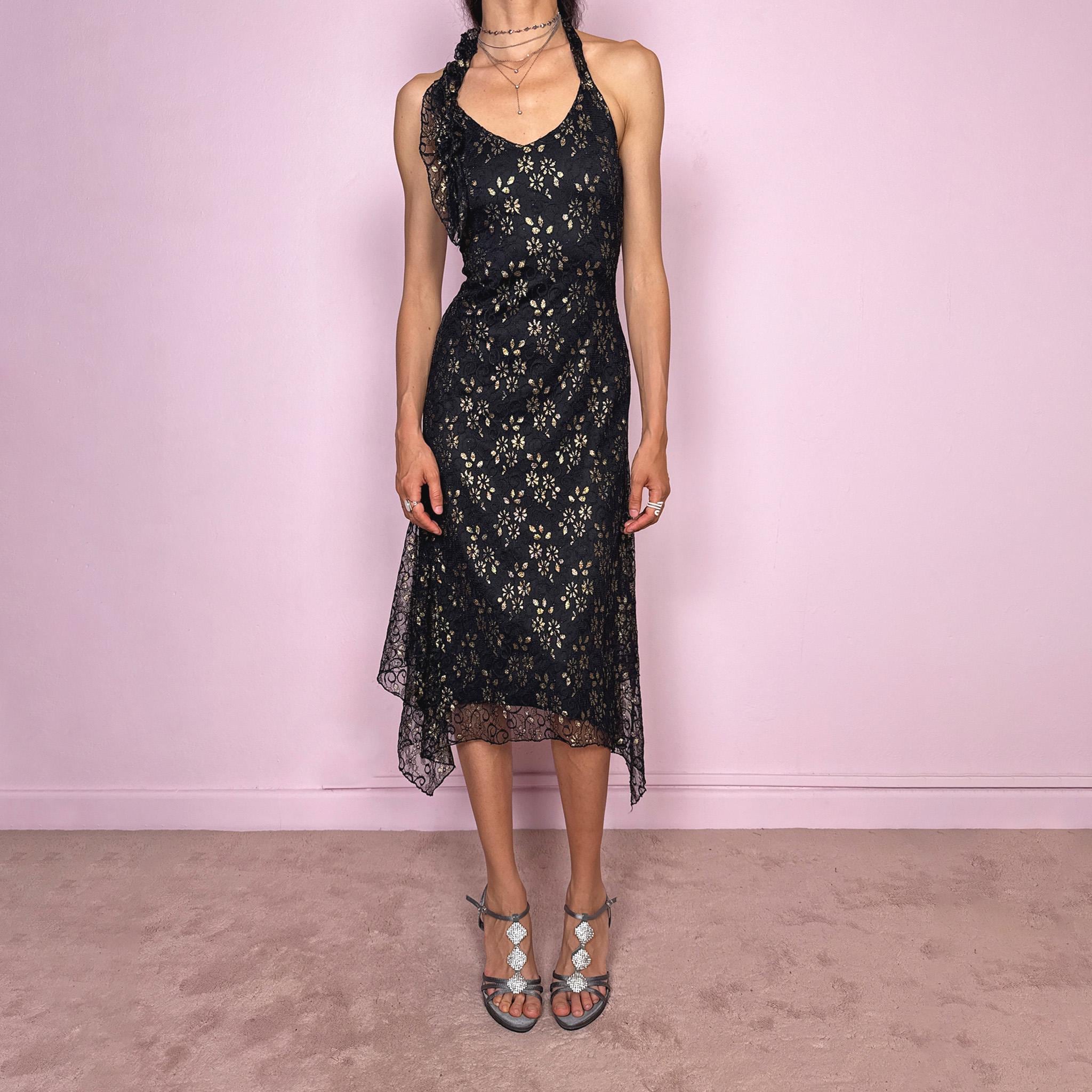 Vintage 2000s black backless halter midi dress with a V neckline, stretchy fit, asymmetric handkerchief hem, and lace mesh overlay with a gold floral pattern. Dark romantic statement piece for parties, nights out, or elegant evening events. Made by a Spanish designer. Excellent vintage condition.