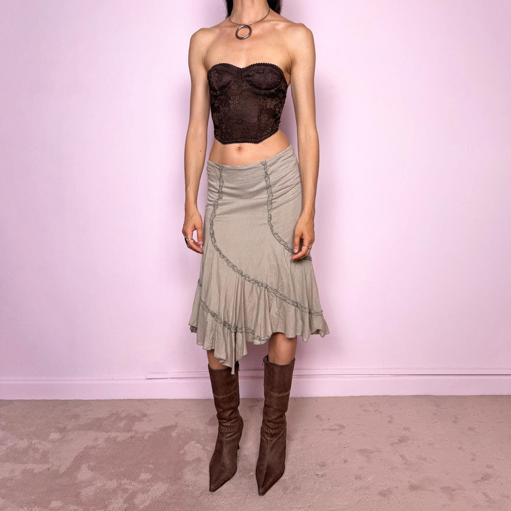 Vintage 2000s light khaki green asymmetric midi skirt made from 100% cotton. Features a side zip closure, no stretch, soft draped panels, and delicate ruffle trim detailing throughout the front and hem. A romantic Y2K bohemian piece in a muted taupe-khaki tone, perfect for fairy summer looks. Can be worn mid-rise for size S or lower rise for XS. Excellent vintage condition.