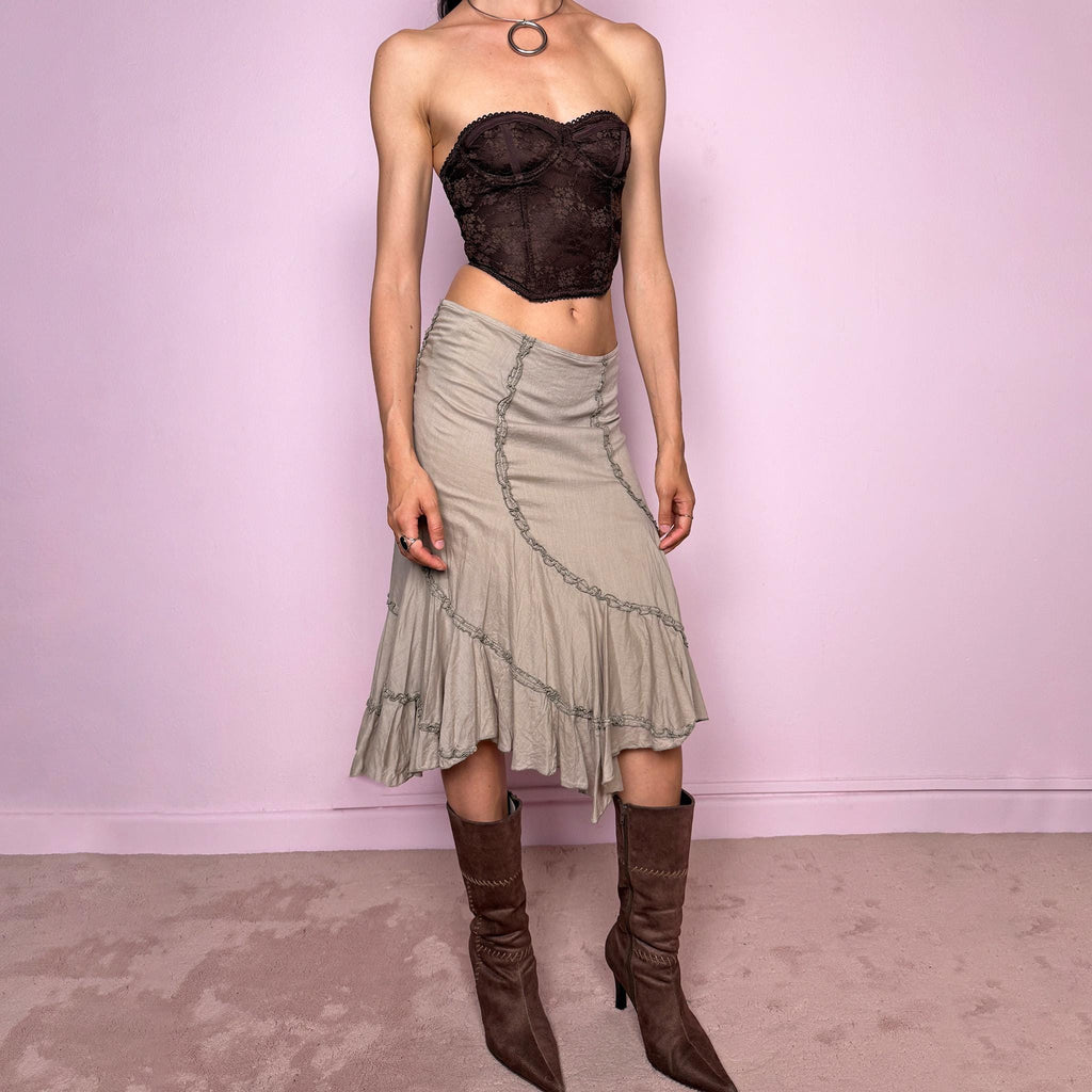 Vintage 2000s light khaki green asymmetric midi skirt made from 100% cotton. Features a side zip closure, no stretch, soft draped panels, and delicate ruffle trim detailing throughout the front and hem. A romantic Y2K bohemian piece in a muted taupe-khaki tone, perfect for fairy summer looks. Can be worn mid-rise for size S or lower rise for XS. Excellent vintage condition.