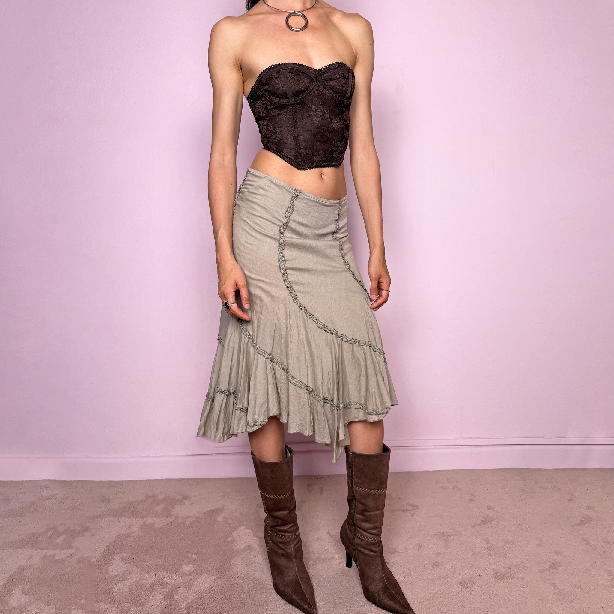 Vintage 2000s light khaki green asymmetric midi skirt made from 100% cotton. Features a side zip closure, no stretch, soft draped panels, and delicate ruffle trim detailing throughout the front and hem. A romantic Y2K bohemian piece in a muted taupe-khaki tone, perfect for fairy summer looks. Can be worn mid-rise for size S or lower rise for XS. Excellent vintage condition.