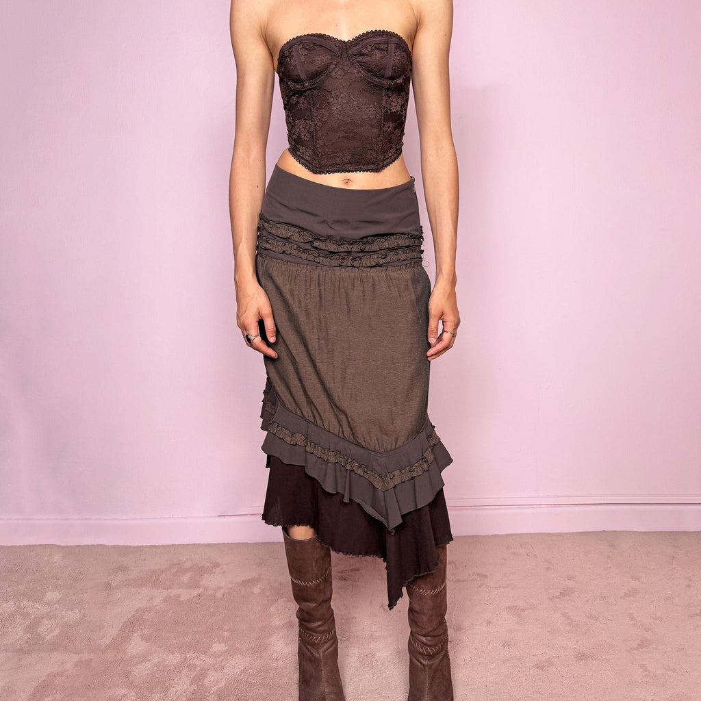 Vintage 2000s brown asymmetric skirt featuring an asymmetric mesh hem, side zip closure, no stretch, layered draped panels, and ruffle trim detailing throughout the waist and hem. Designed in a dark earthy brown tone with a romantic bohemian Y2K feel, perfect for fairy autumn looks. Can be worn high-waisted for size S or lower rise for XS. Made by a French brand. Excellent vintage condition.