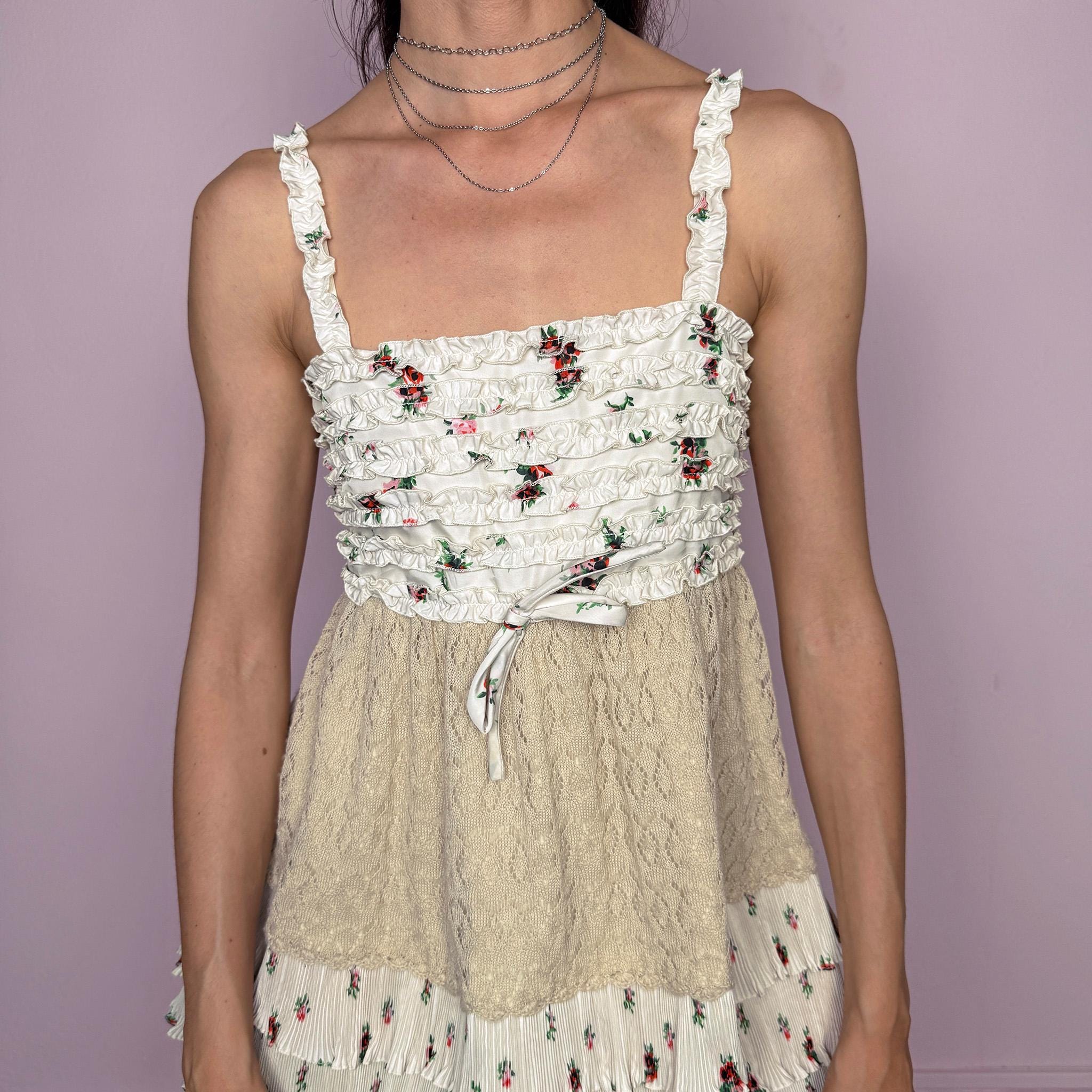 Vintage 2000s romantic ruffled cami top in a delicate cream floral print with layered pleated details, beige knit paneling, and a feminine fitted babydoll-style silhouette. Featuring tiered ruffle trims, a 70% silk and 30% wool knit blend overlay through the waist, and a back zip closure. No stretch. Rare Y2K designer piece with a romantic bohemian/fairy-like aesthetic. Made by the French brand Manoush, with lining and other fabric made from a cotton-polyester blend. Great vintage condition.