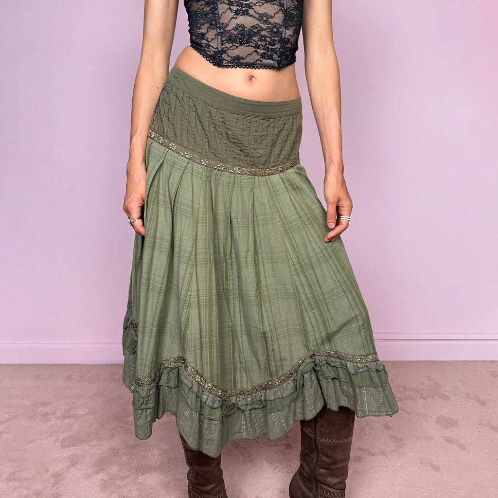 Vintage 2000s olive green khaki midi skirt with a soft bohemian feel, featuring a gathered silhouette, pleated waist panel, and layered ruffle hem with floral embroidered trim details. Designed in non-stretch 100% cotton fabric with a side zip closure, the skirt has a romantic, earthy look. Can be worn mid-rise for size L. Great vintage condition.