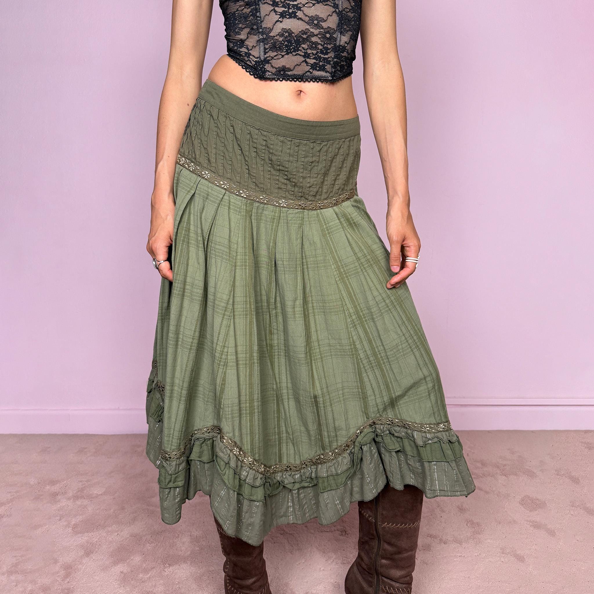 Vintage 2000s olive green khaki midi skirt with a soft bohemian feel, featuring a gathered silhouette, pleated waist panel, and layered ruffle hem with floral embroidered trim details. Designed in non-stretch 100% cotton fabric with a side zip closure, the skirt has a romantic, earthy look. Can be worn mid-rise for size L. Great vintage condition.
