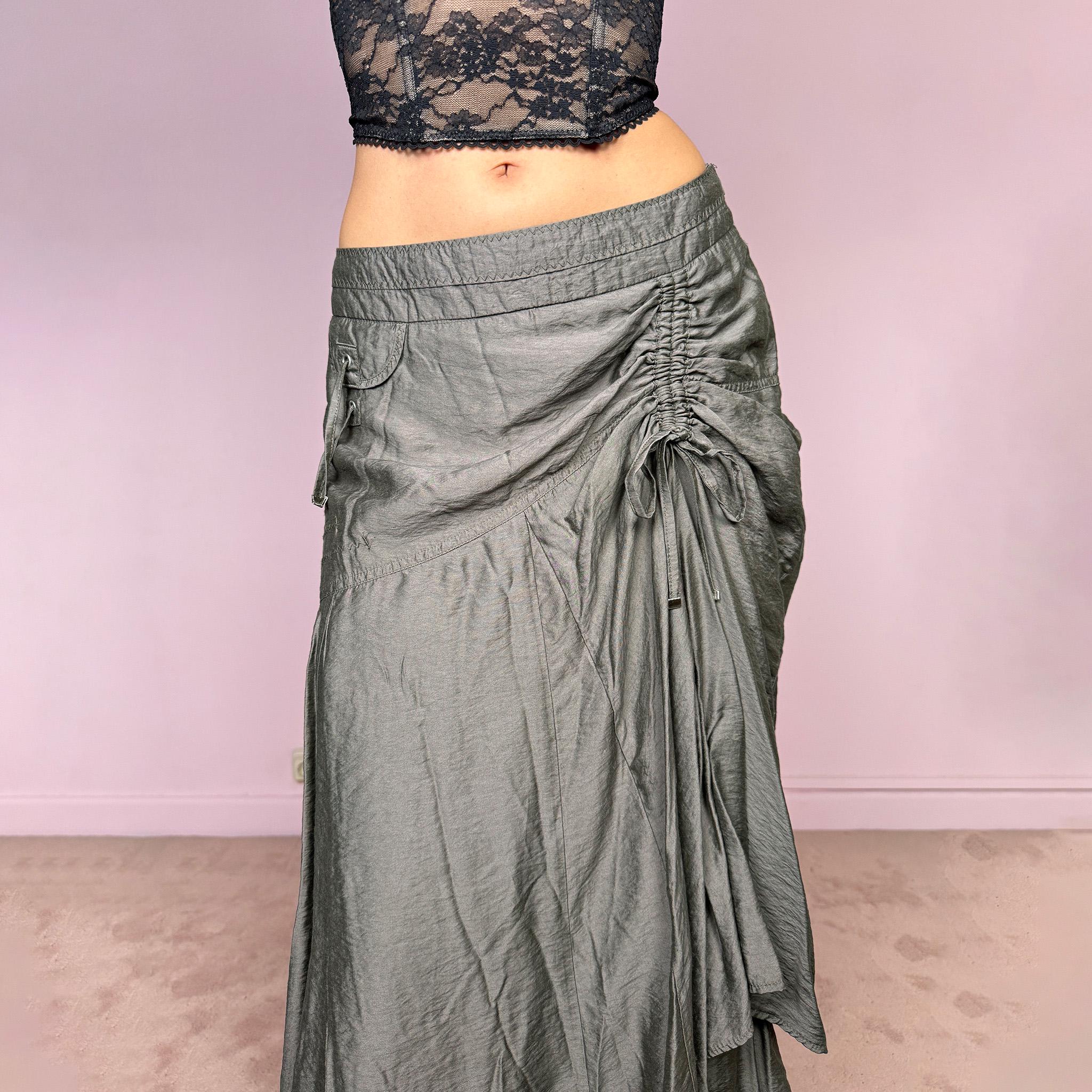 Vintage 2000s greenish-gray layered midi skirt featuring a fluid draped silhouette, ruched side detail with tie accents, and a softly flared layered hem. Designed in a non-stretch 83% viscose-blend fabric with a side zip closure and full polyester lining, the skirt has an avant-garde deconstructed aesthetic. Can be worn high-waisted for size L or lower-rise for M. Great vintage condition.
