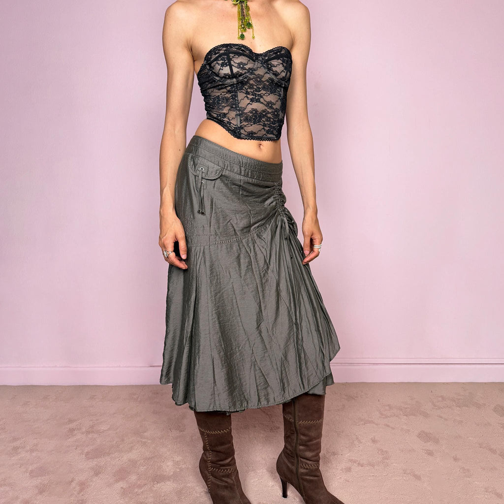 Vintage 2000s greenish-gray layered midi skirt featuring a fluid draped silhouette, ruched side detail with tie accents, and a softly flared layered hem. Designed in a non-stretch 83% viscose-blend fabric with a side zip closure and full polyester lining, the skirt has an avant-garde deconstructed aesthetic. Can be worn high-waisted for size L or lower-rise for M. Great vintage condition.