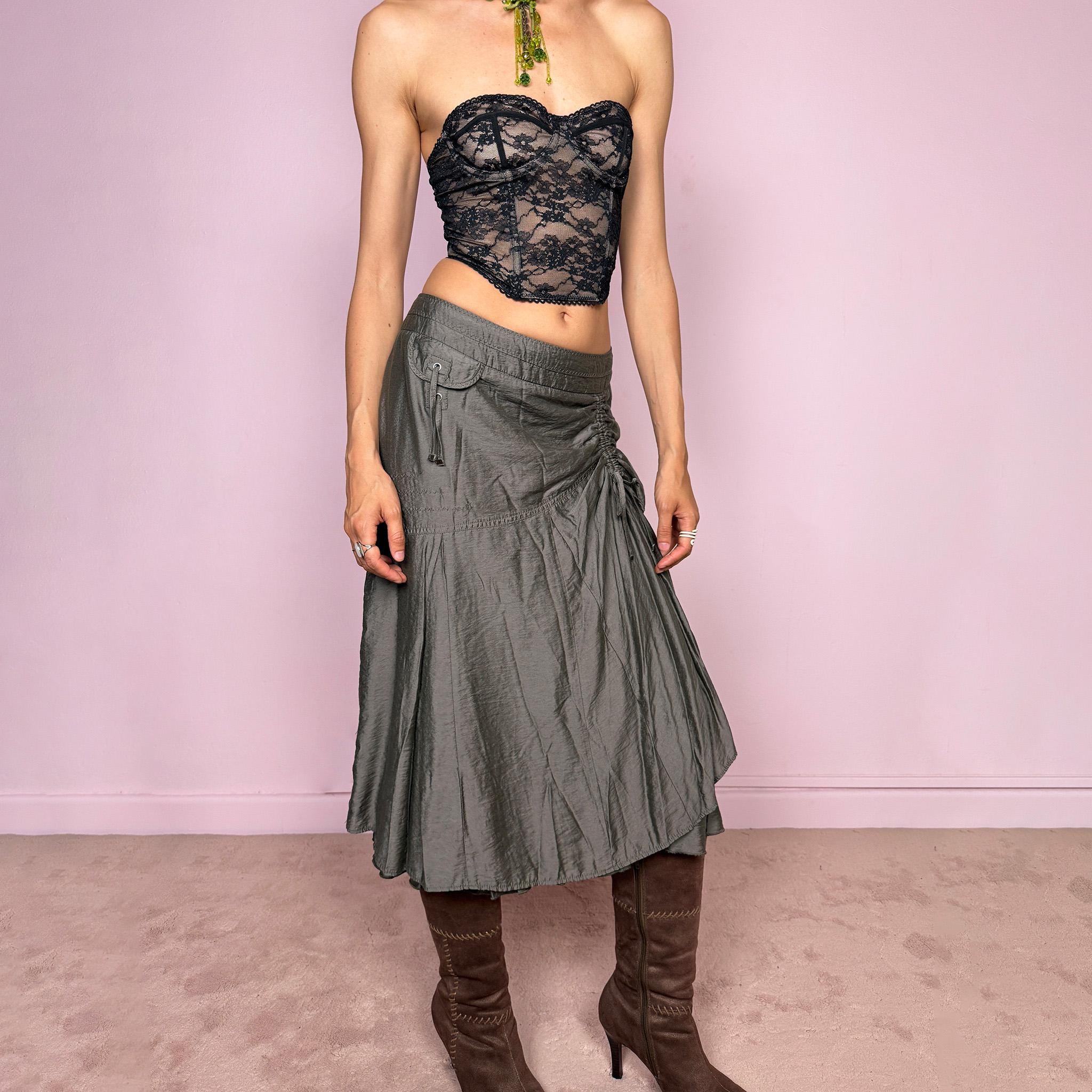 Vintage 2000s greenish-gray layered midi skirt featuring a fluid draped silhouette, ruched side detail with tie accents, and a softly flared layered hem. Designed in a non-stretch 83% viscose-blend fabric with a side zip closure and full polyester lining, the skirt has an avant-garde deconstructed aesthetic. Can be worn high-waisted for size L or lower-rise for M. Great vintage condition.