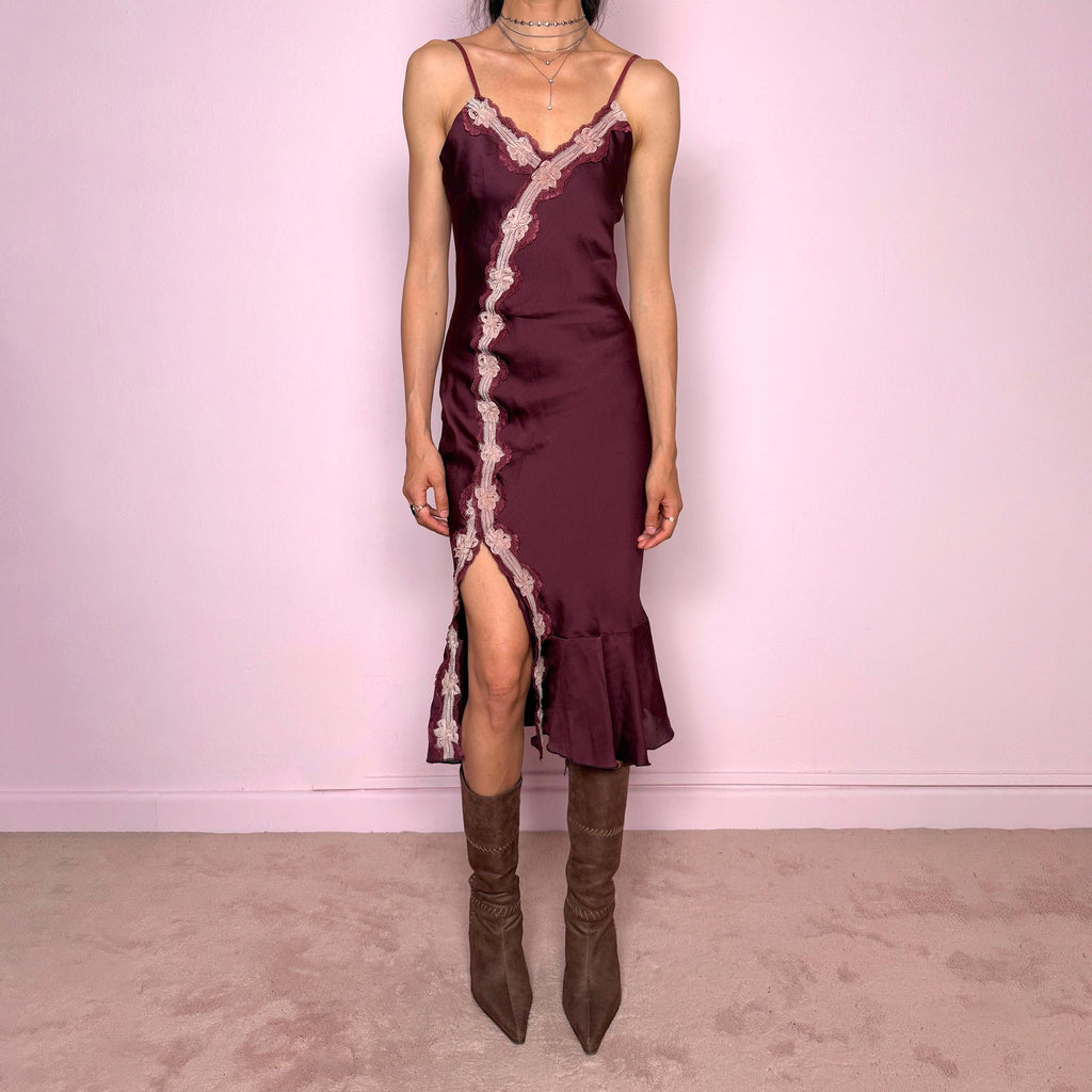 Vintage 2000s burgundy-plum satin-style slip midi dress. Features delicate adjustable straps, a romantic pink lace appliqué trim, asymmetric front detail, high front slit, and a softly flared ruffle hem. Designed in a smooth polyester fabric with no stretch and a feminine body-skimming silhouette. A romantic Y2K evening dress, perfect for dreamy soirées, made in France by a French brand. Excellent vintage condition.
