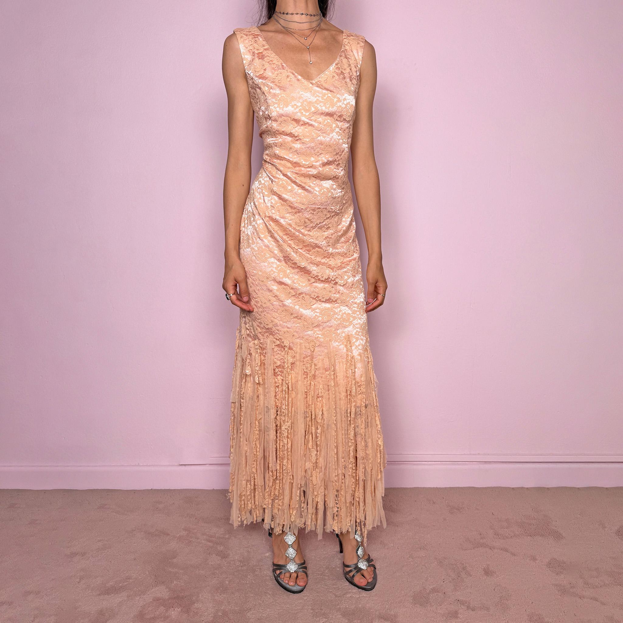 Vintage 2000s pastel peach lace maxi dress. Features a romantic V-neckline, fitted sleeveless silhouette, side zip closure, and a dramatic fringed lace hem. A refined occasion dress in a soft peach, salmon, and blush pink tone, perfect for romantic evening styling, spring-summer events, weddings, or elevated vintage looks. Made in Spain by a Spanish designer, with a nylon-cotton blend outer layer and polyester lining, with no stretch. Excellent vintage condition.