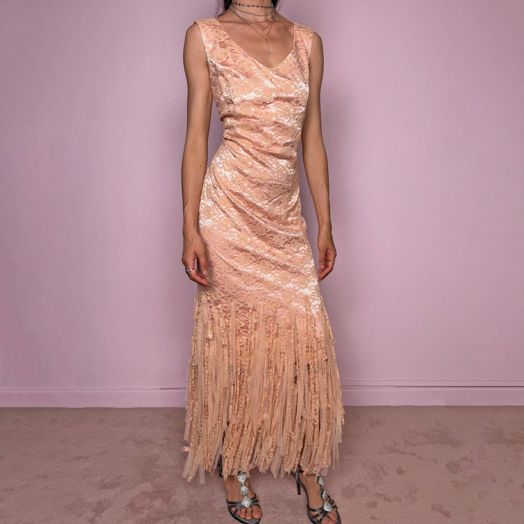 Vintage 2000s pastel peach lace maxi dress. Features a romantic V-neckline, fitted sleeveless silhouette, side zip closure, and a dramatic fringed lace hem. A refined occasion dress in a soft peach, salmon, and blush pink tone, perfect for romantic evening styling, spring-summer events, weddings, or elevated vintage looks. Made in Spain by a Spanish designer, with a nylon-cotton blend outer layer and polyester lining, with no stretch. Excellent vintage condition.