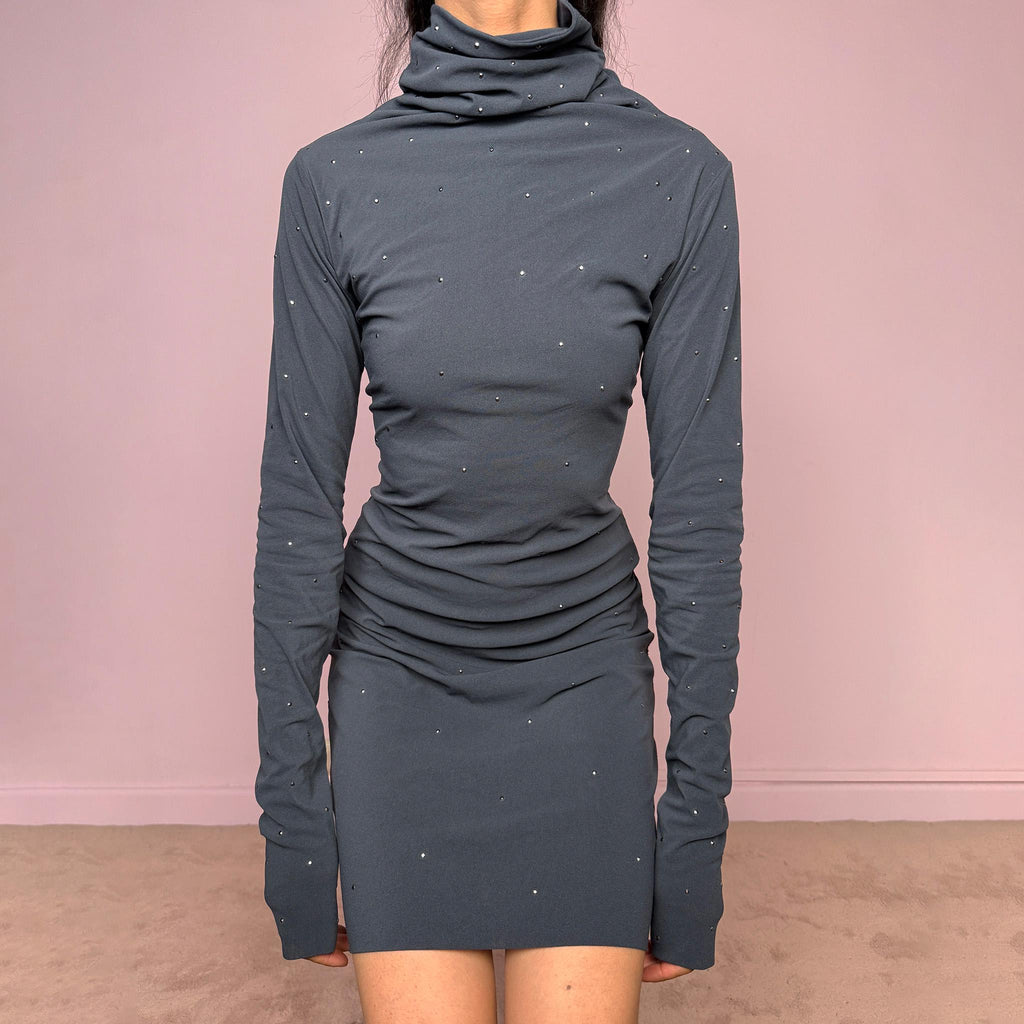 Vintage 2000s gray mini dress made in Italy from a stretchy polyamide-elastane mesh fabric. Features long sleeves, a draped high neckline, a body-skimming silhouette that flares at the hem, and delicate mini studded details throughout. A sleek dark minimal Y2K piece with an avant-garde feel. Excellent vintage condition.