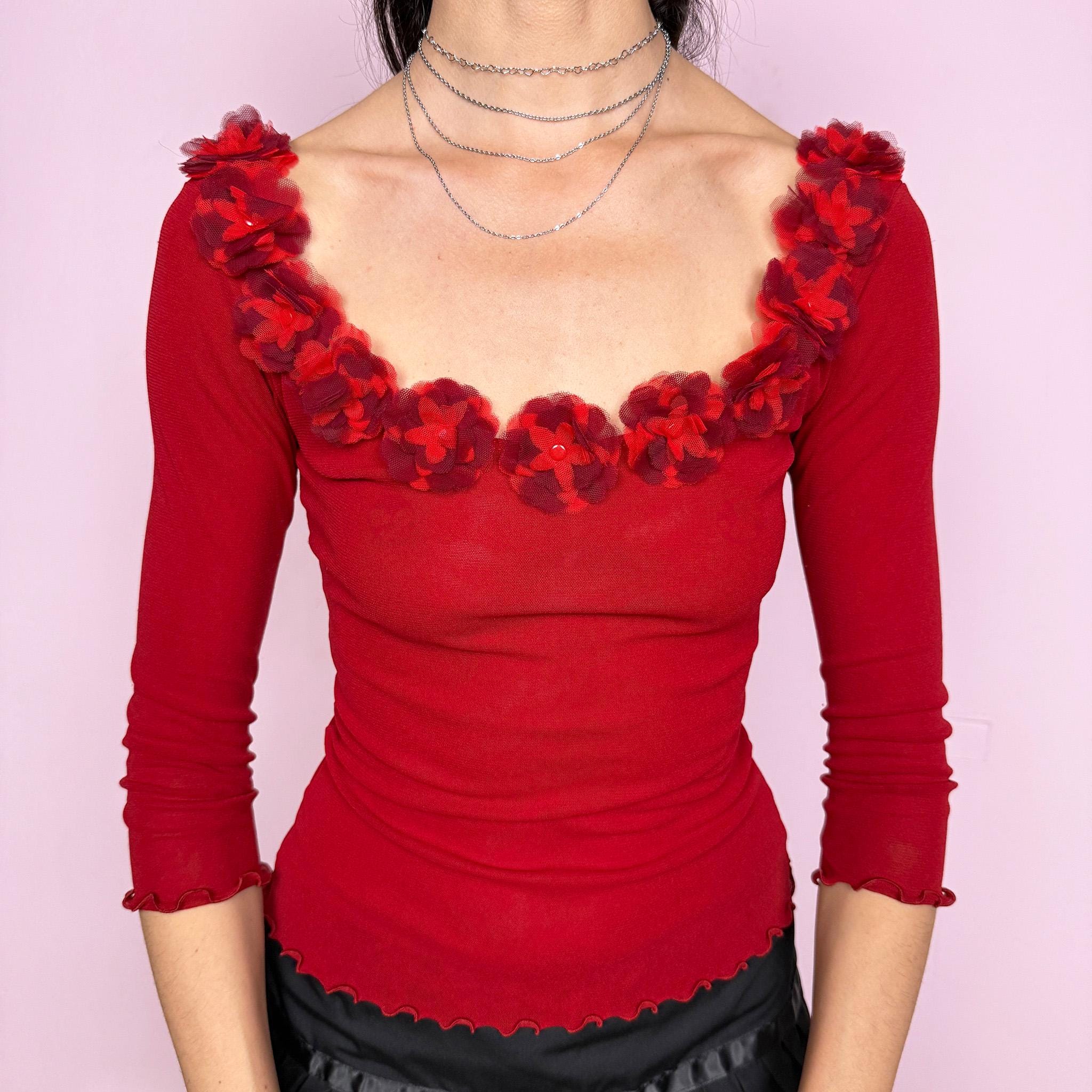 Vintage 2000s Moschino Jeans red mesh top featuring a fitted silhouette, 3/4 sleeves and sculptural floral appliqué trim along the neckline. Designed in a bold red tone with a soft stretchy semi-sheer finish and delicate lettuce-edge hems. A striking Italian designer Y2K piece, perfect for evening styling or elevated statement looks. Made in Italy. Fabric composition unknown due to missing label. Excellent vintage condition.