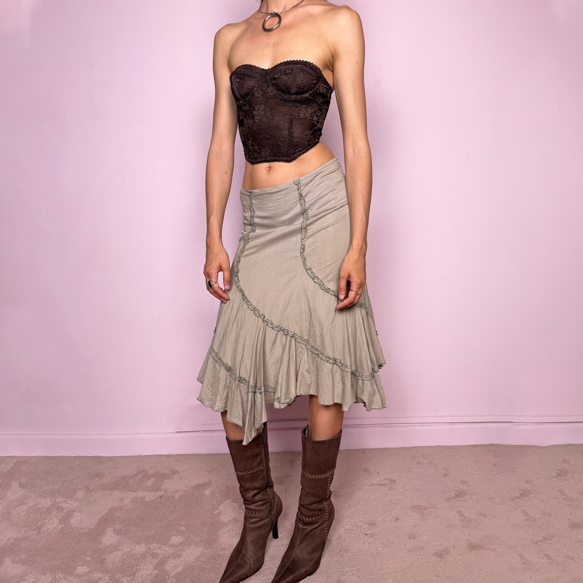 Vintage 2000s light khaki green asymmetric midi skirt made from 100% cotton. Features a side zip closure, no stretch, soft draped panels, and delicate ruffle trim detailing throughout the front and hem. A romantic Y2K bohemian piece in a muted taupe-khaki tone, perfect for fairy summer looks. Can be worn mid-rise for size S or lower rise for XS. Excellent vintage condition.
