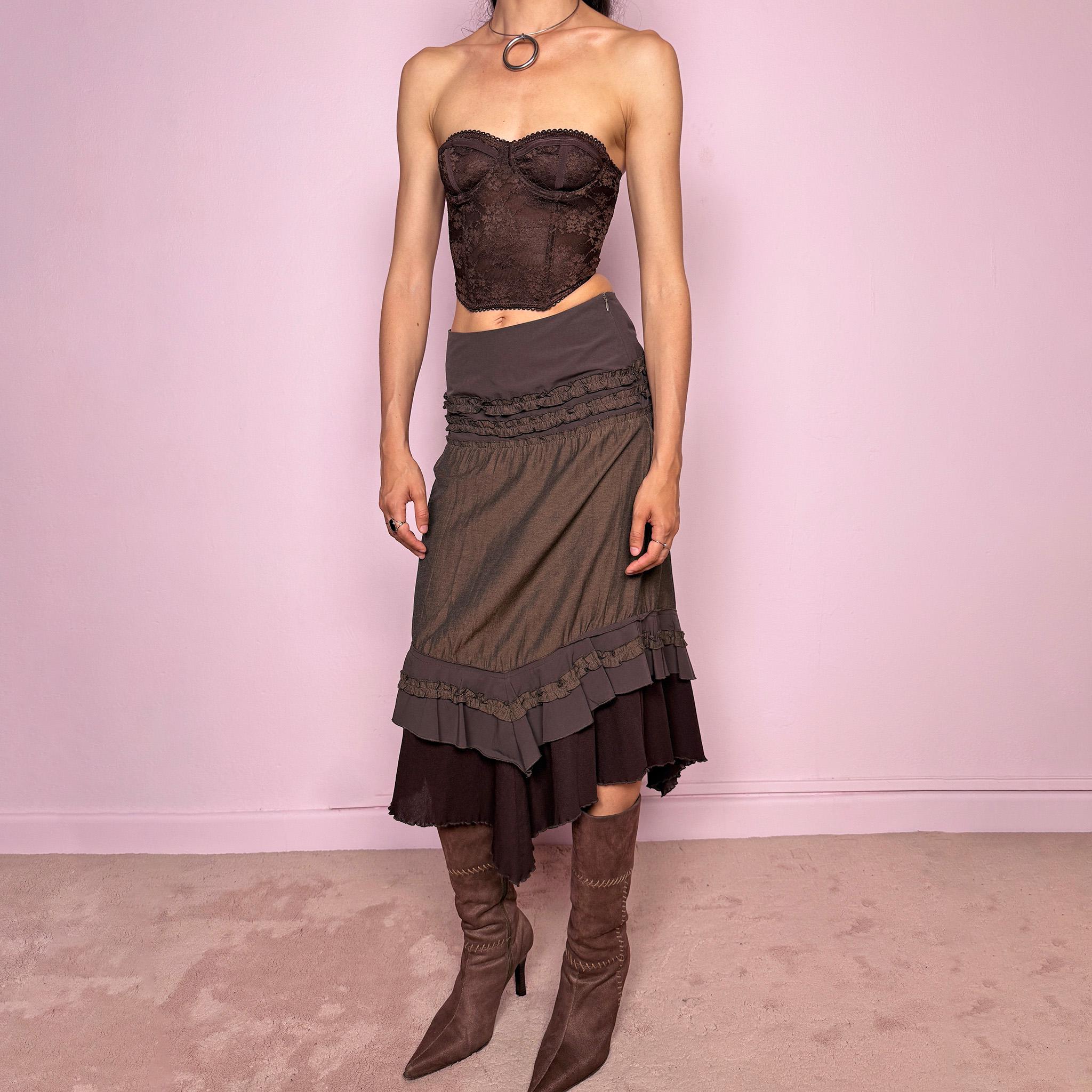 Vintage 2000s brown asymmetric skirt featuring an asymmetric mesh hem, side zip closure, no stretch, layered draped panels, and ruffle trim detailing throughout the waist and hem. Designed in a dark earthy brown tone with a romantic bohemian Y2K feel, perfect for fairy autumn looks. Can be worn high-waisted for size S or lower rise for XS. Made by a French brand. Excellent vintage condition.