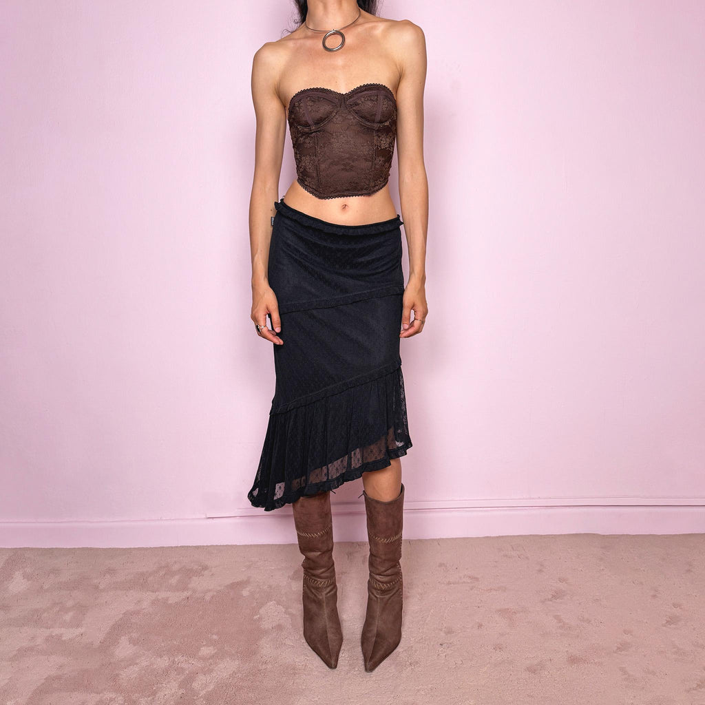 Vintage 2000s Moschino Jeans black lace asymmetric midi skirt made in Italy from a stretchy polyamide fabric. Features a low-rise, soft stretch waistband without elastic, delicate ruffle trim, layered asymmetric panels, and a sheer lace pleated hem. A dark romantic Y2K designer piece, perfect for elevated evening looks. Excellent vintage condition.